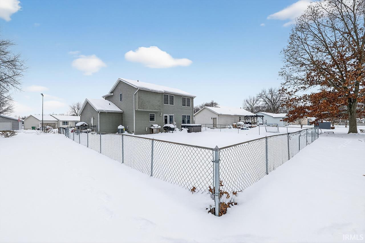 View of snow covered back of property