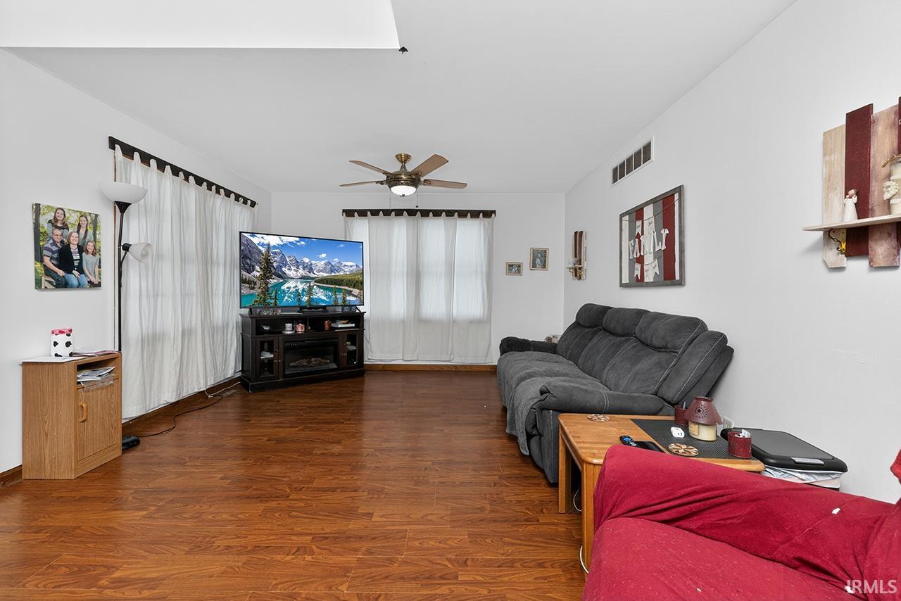 Living room with wood finished floors and a ceiling fan