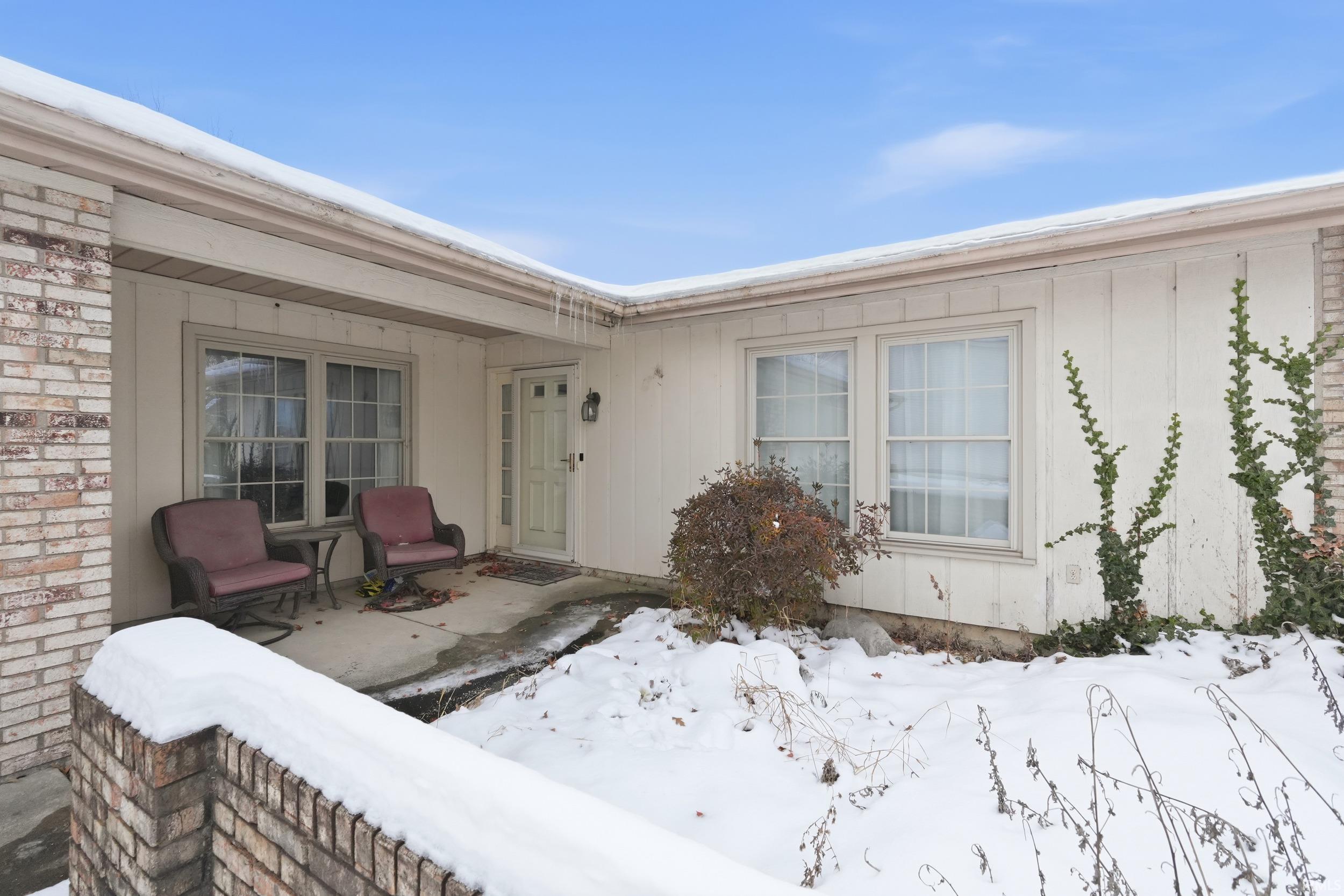 Snow covered property entrance featuring a patio area