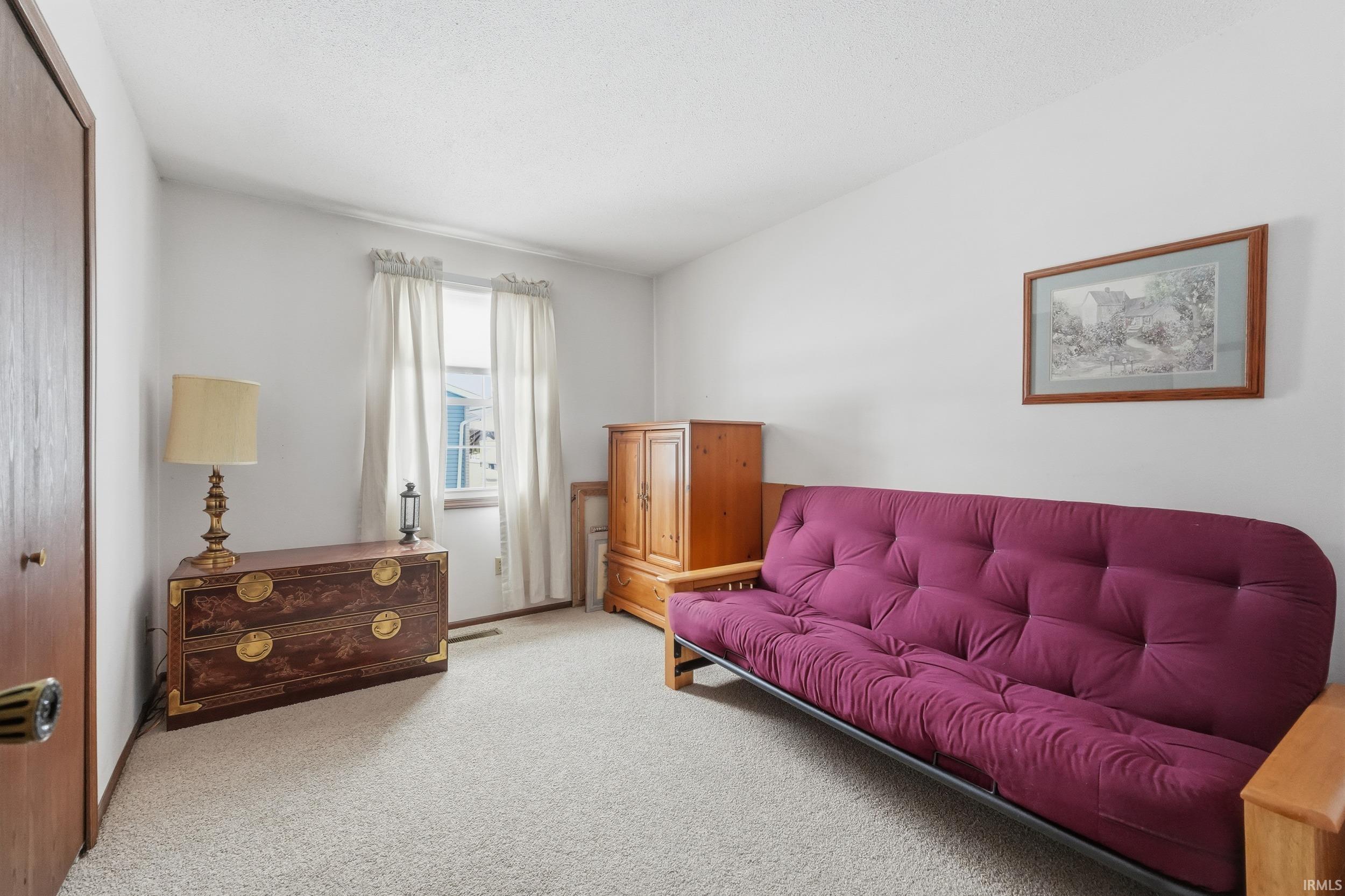 Living area with carpet flooring and a textured ceiling
