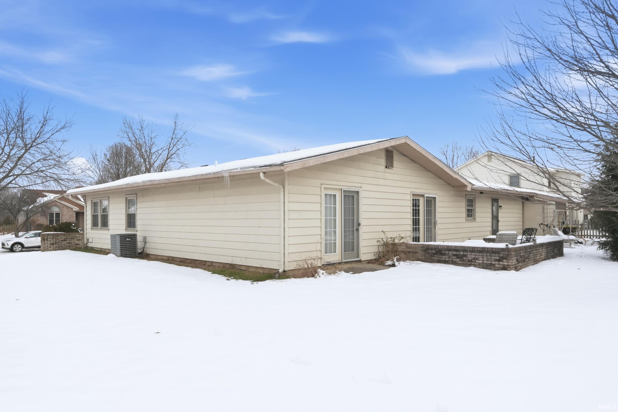Snow covered property with a patio area