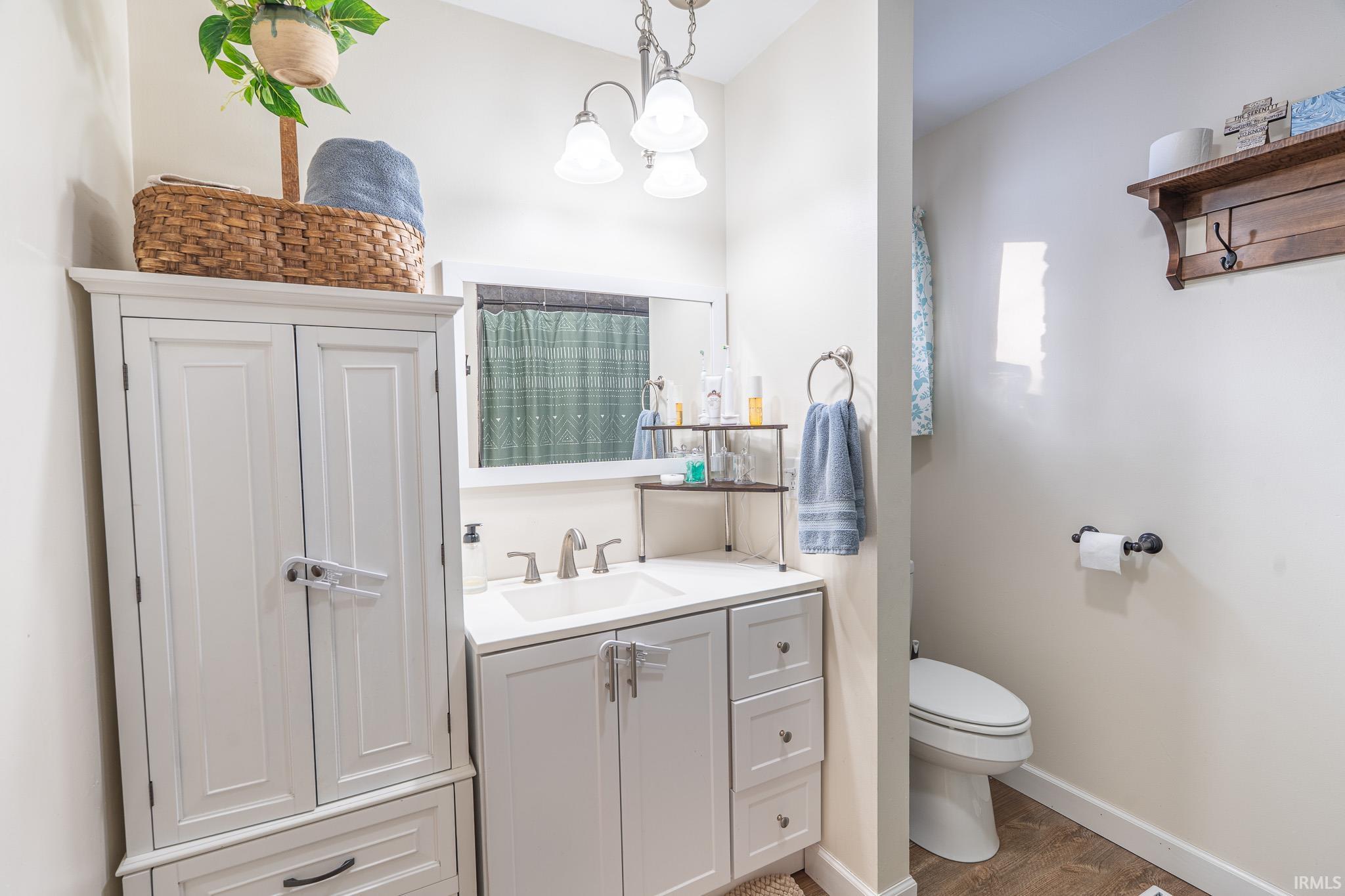 Bathroom with curtained shower, vanity, and light wood-type flooring