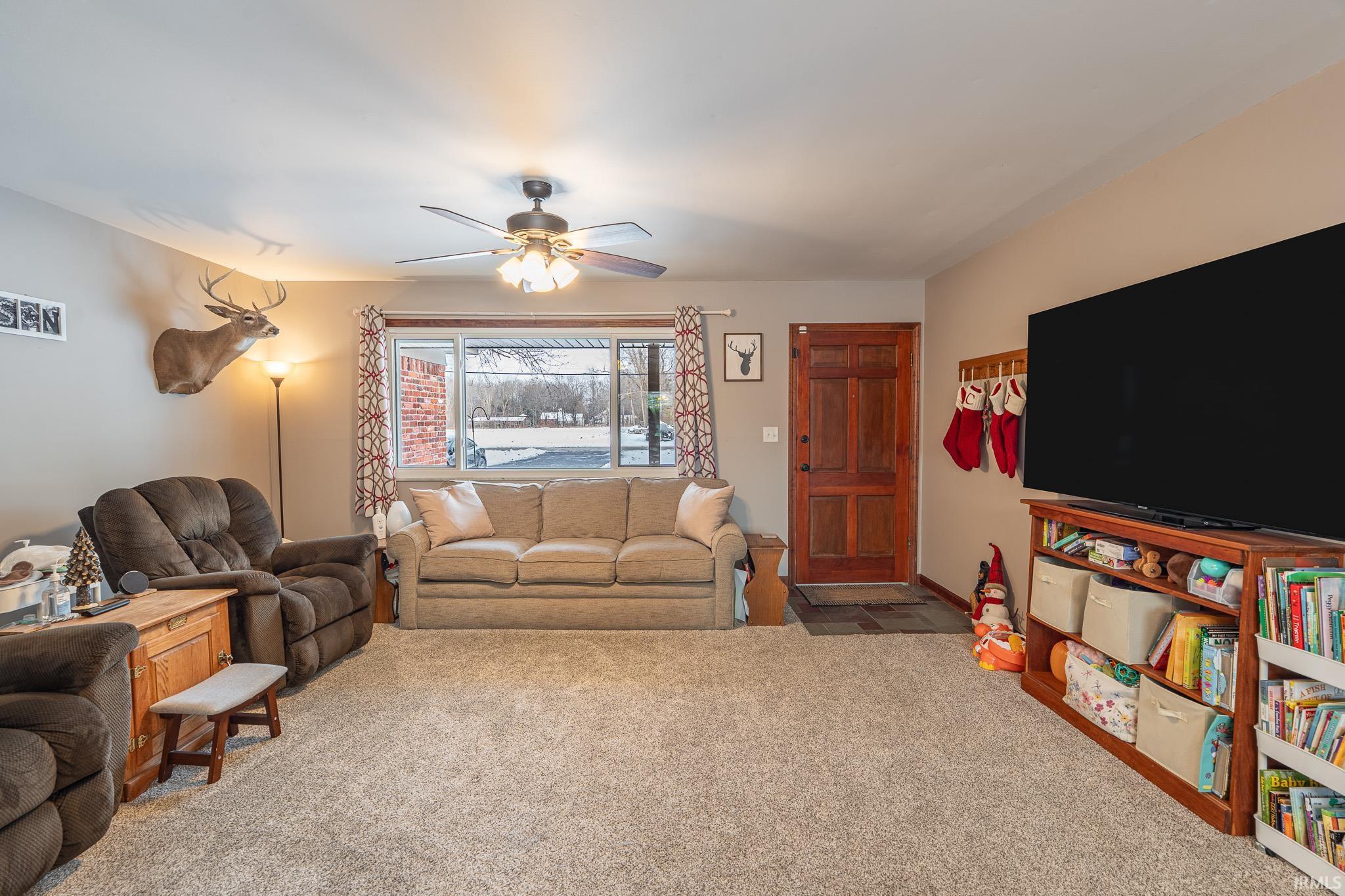 Living room with carpet flooring and ceiling fan