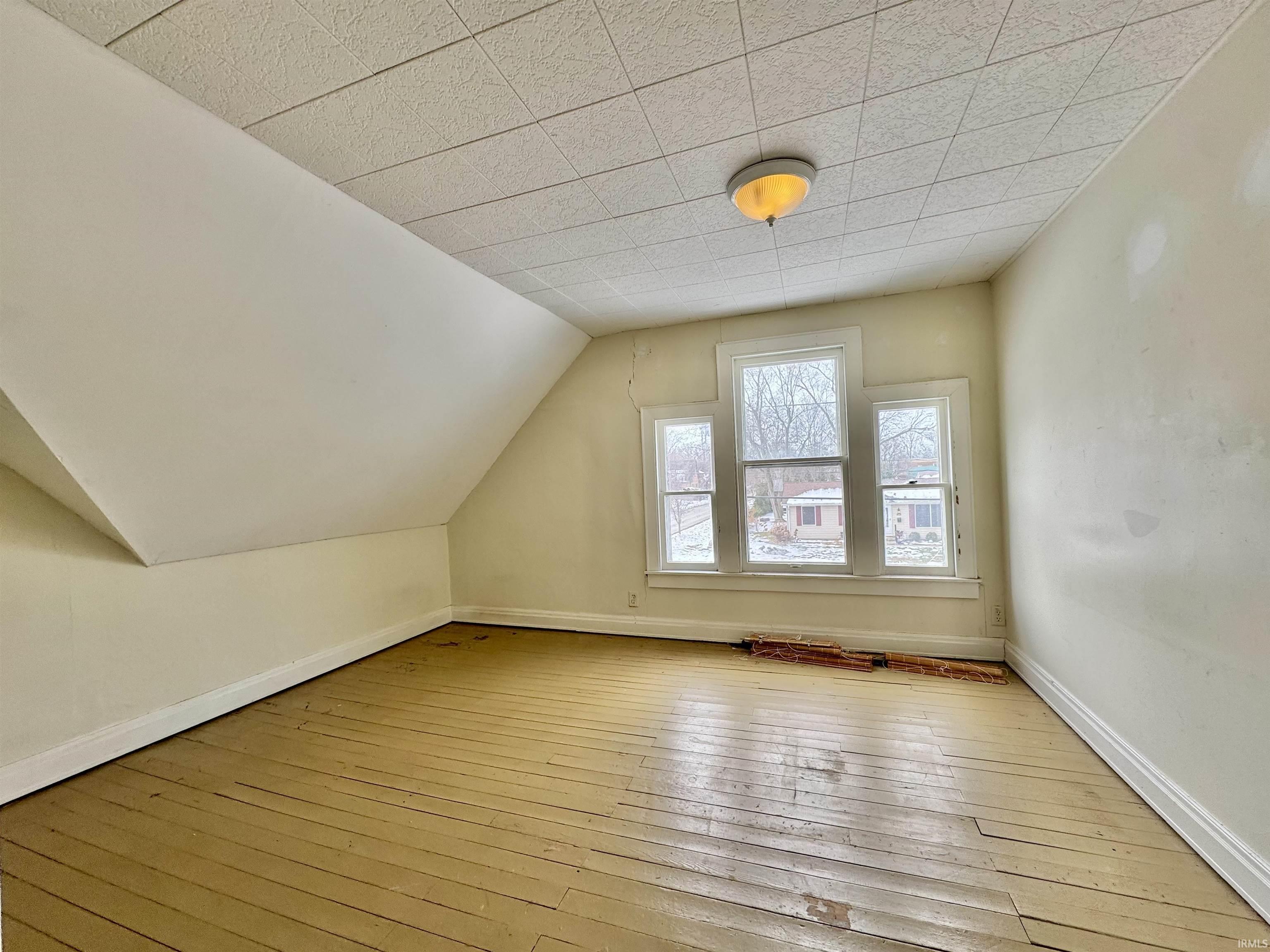 Bonus room featuring hardwood / wood-style flooring and lofted ceiling