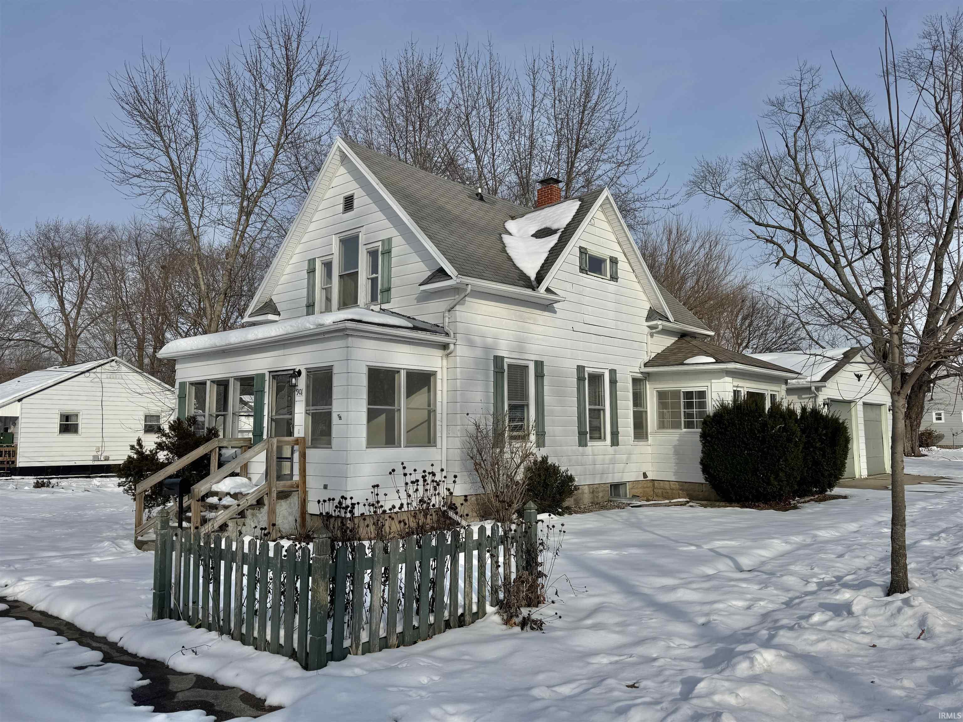 View of front of home featuring a chimney and a garage
