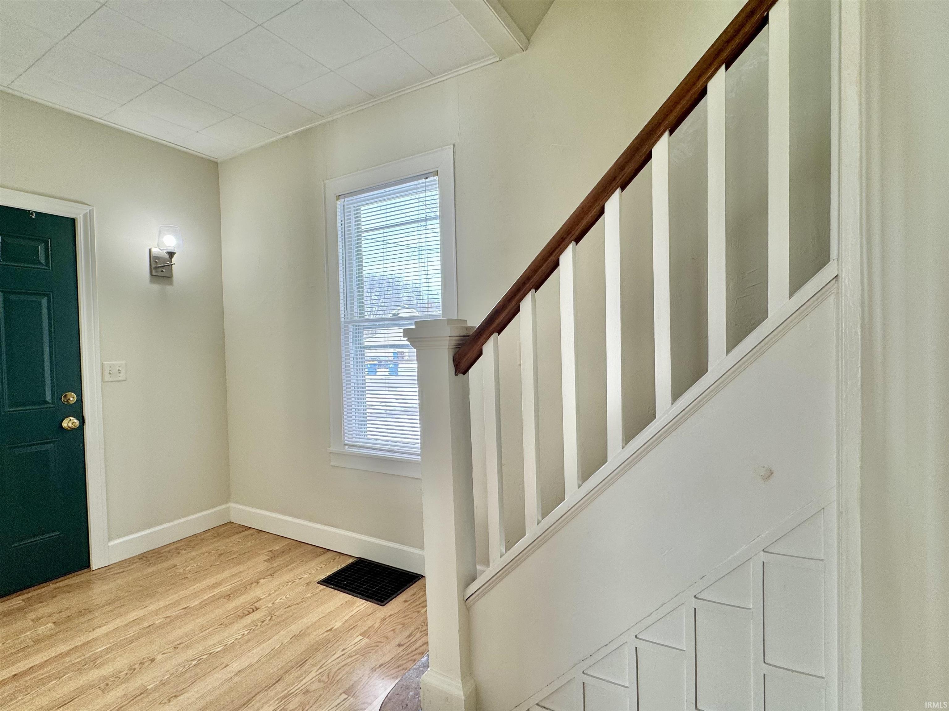 Foyer entrance with stairs and light wood-style floors