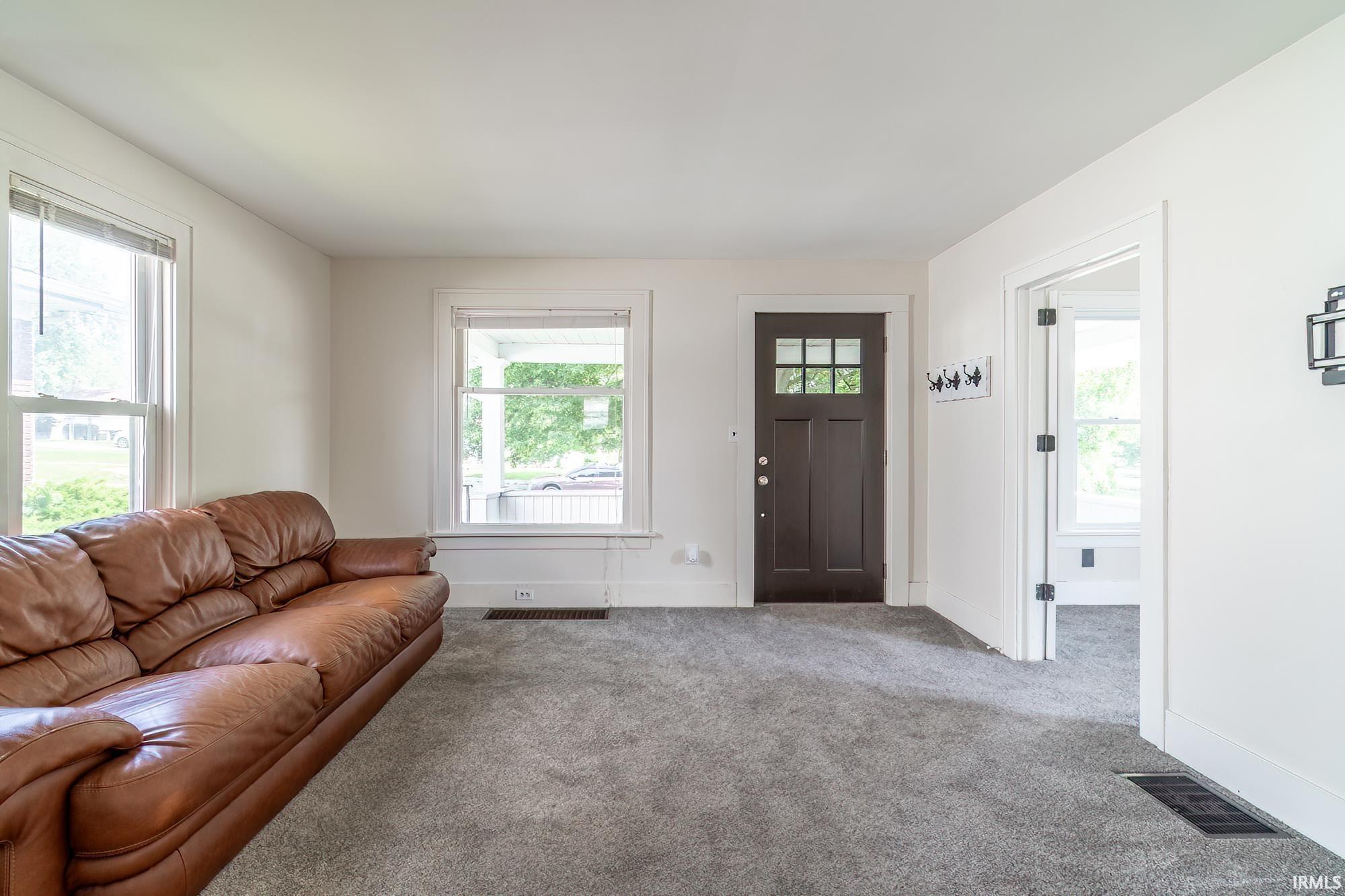 Carpeted living area featuring baseboards
