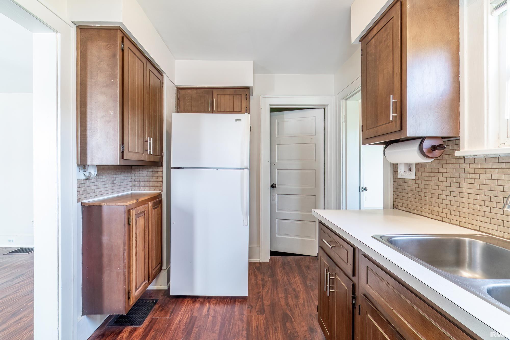 Kitchen with freestanding refrigerator, backsplash, and light countertops