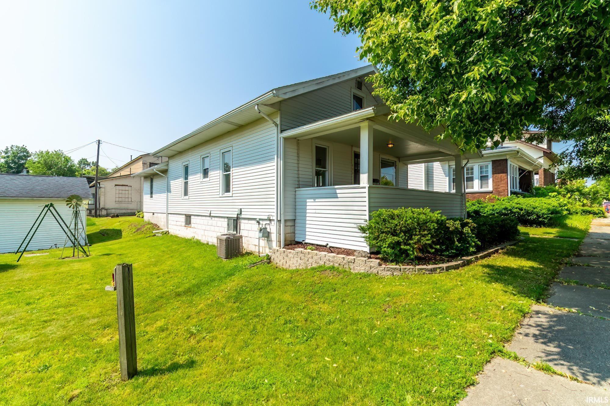 View of home's exterior with a lawn and covered porch