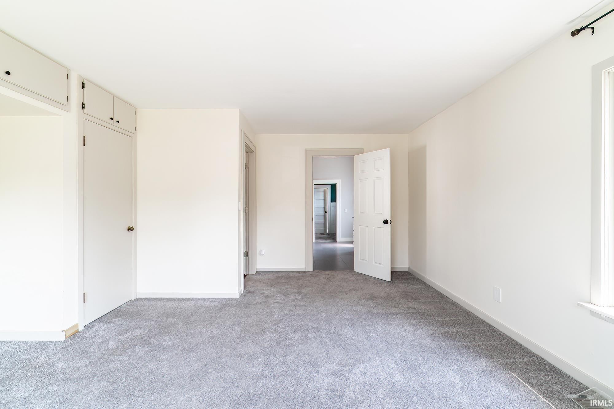 Unfurnished bedroom featuring light carpet and a closet