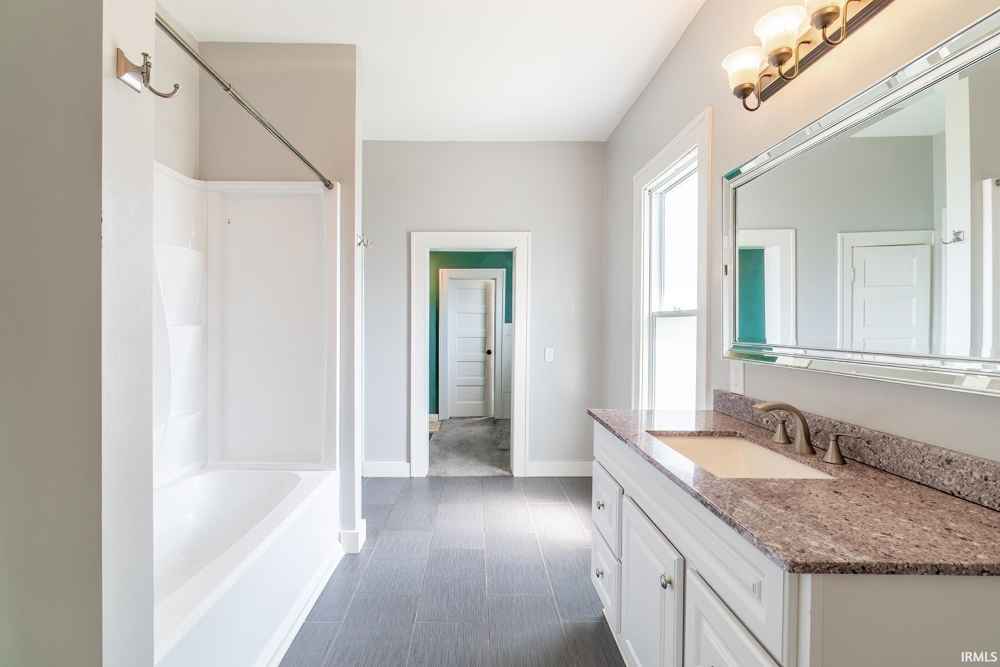 Bathroom with vanity and bathing tub / shower combination