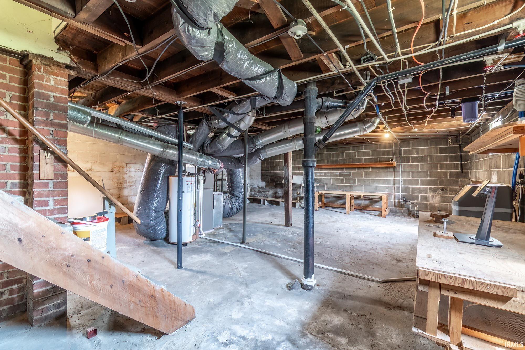 Unfinished below grade area with gas water heater and heating unit