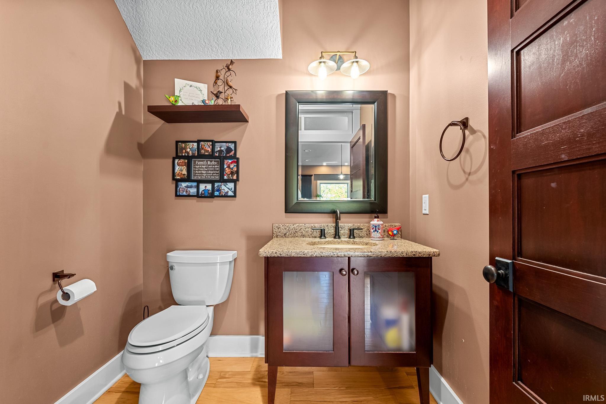 Half bath featuring vanity and light wood-style floors