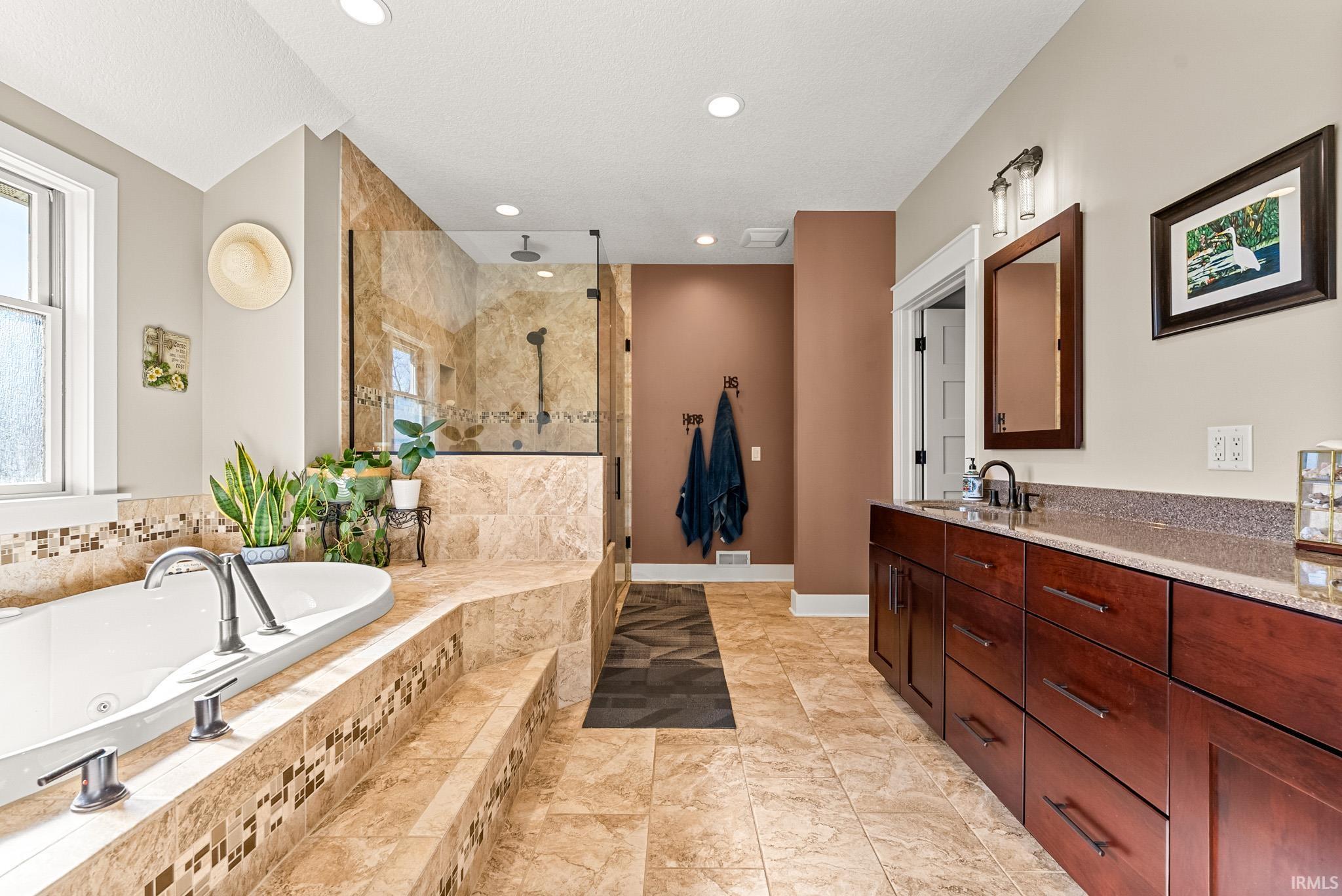 Full bathroom with a jetted tub, vanity, a stall shower, recessed lighting, and light tile patterned floors