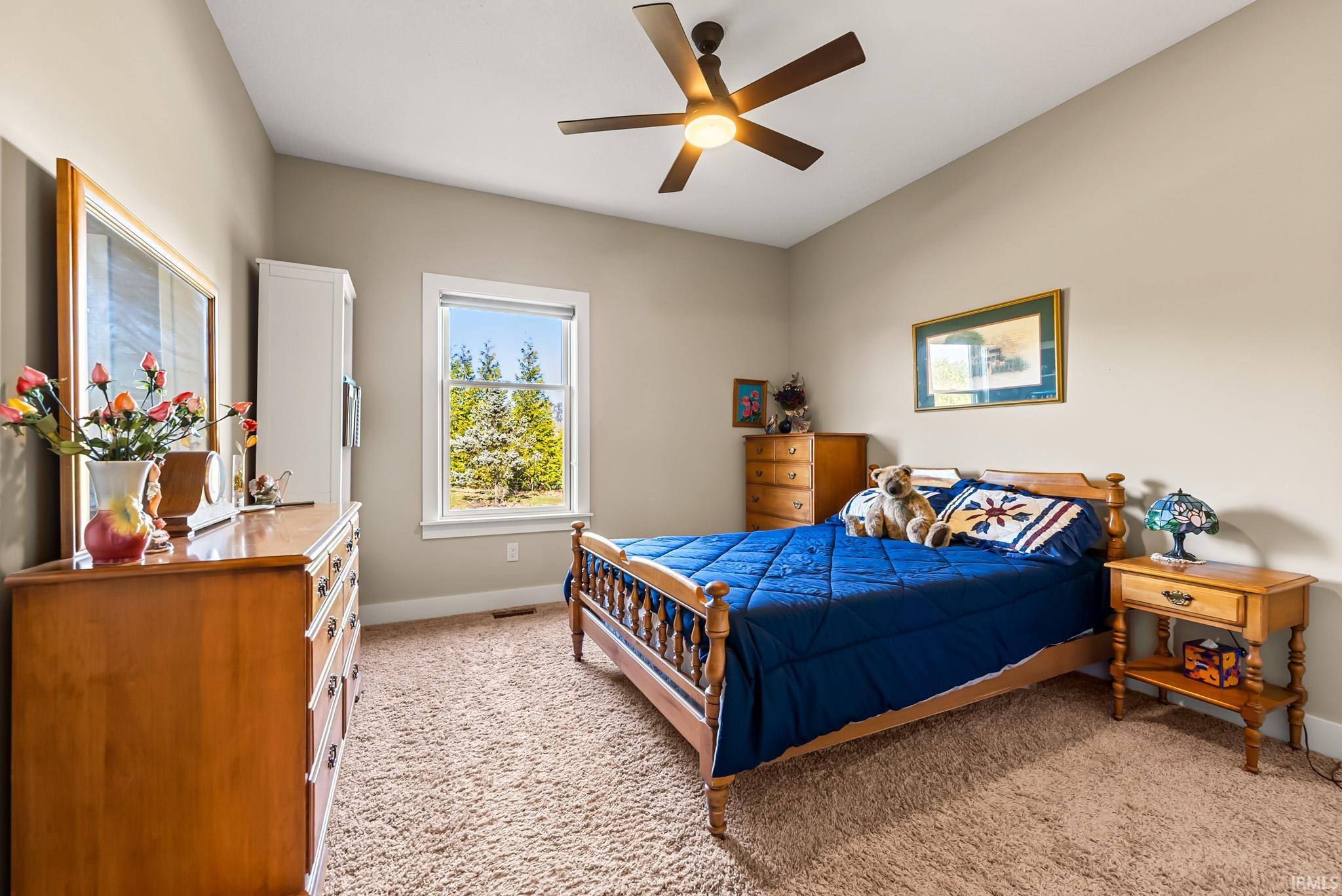 Bedroom featuring light carpet and a ceiling fan