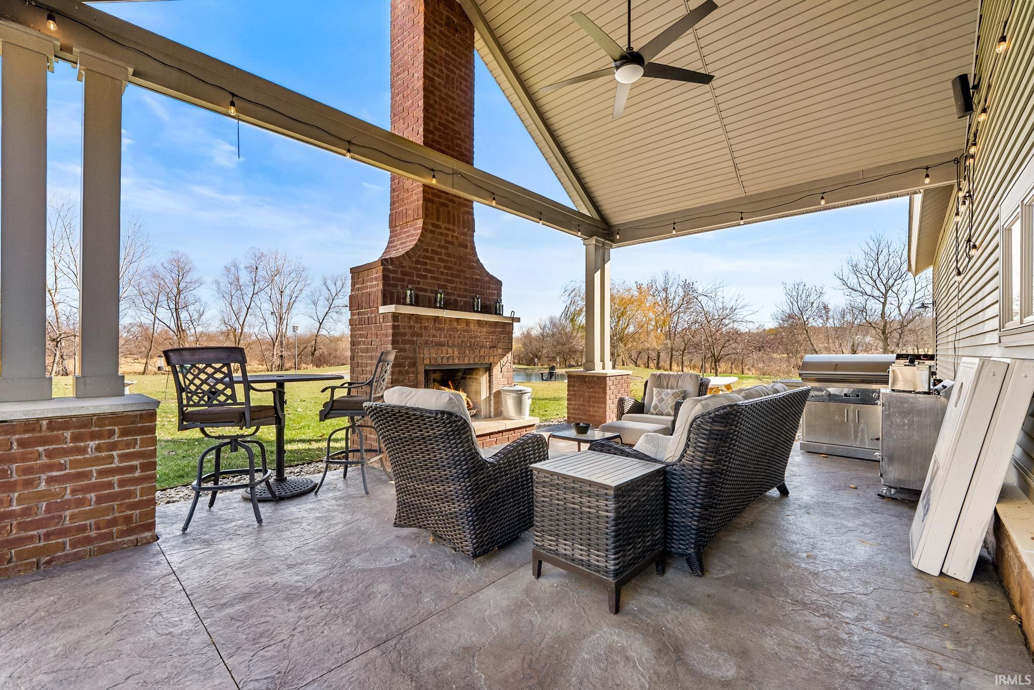 View of patio / terrace featuring ceiling fan, area for grilling, and an outdoor living space with a fireplace