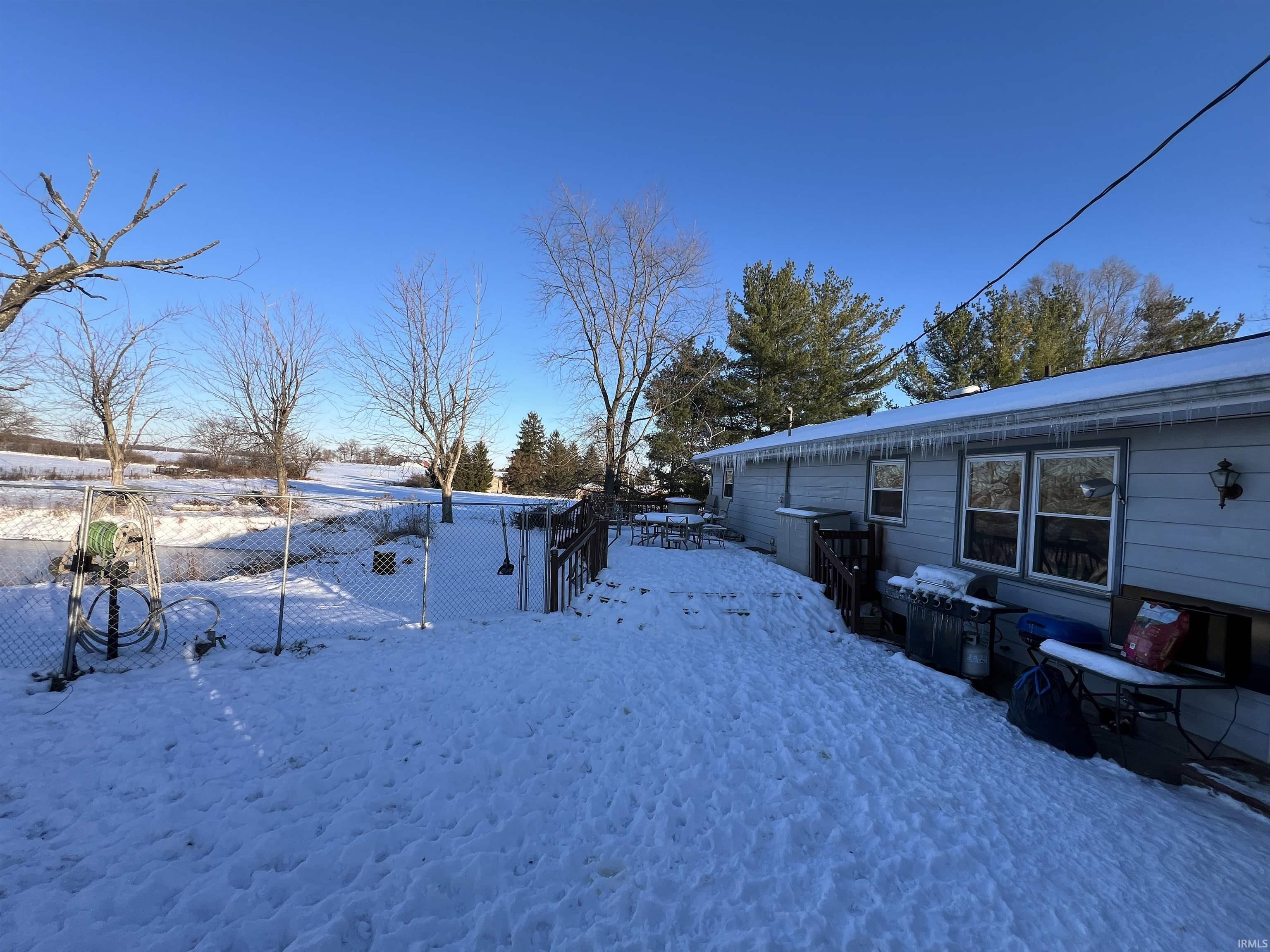 Yard layered in snow featuring a deck