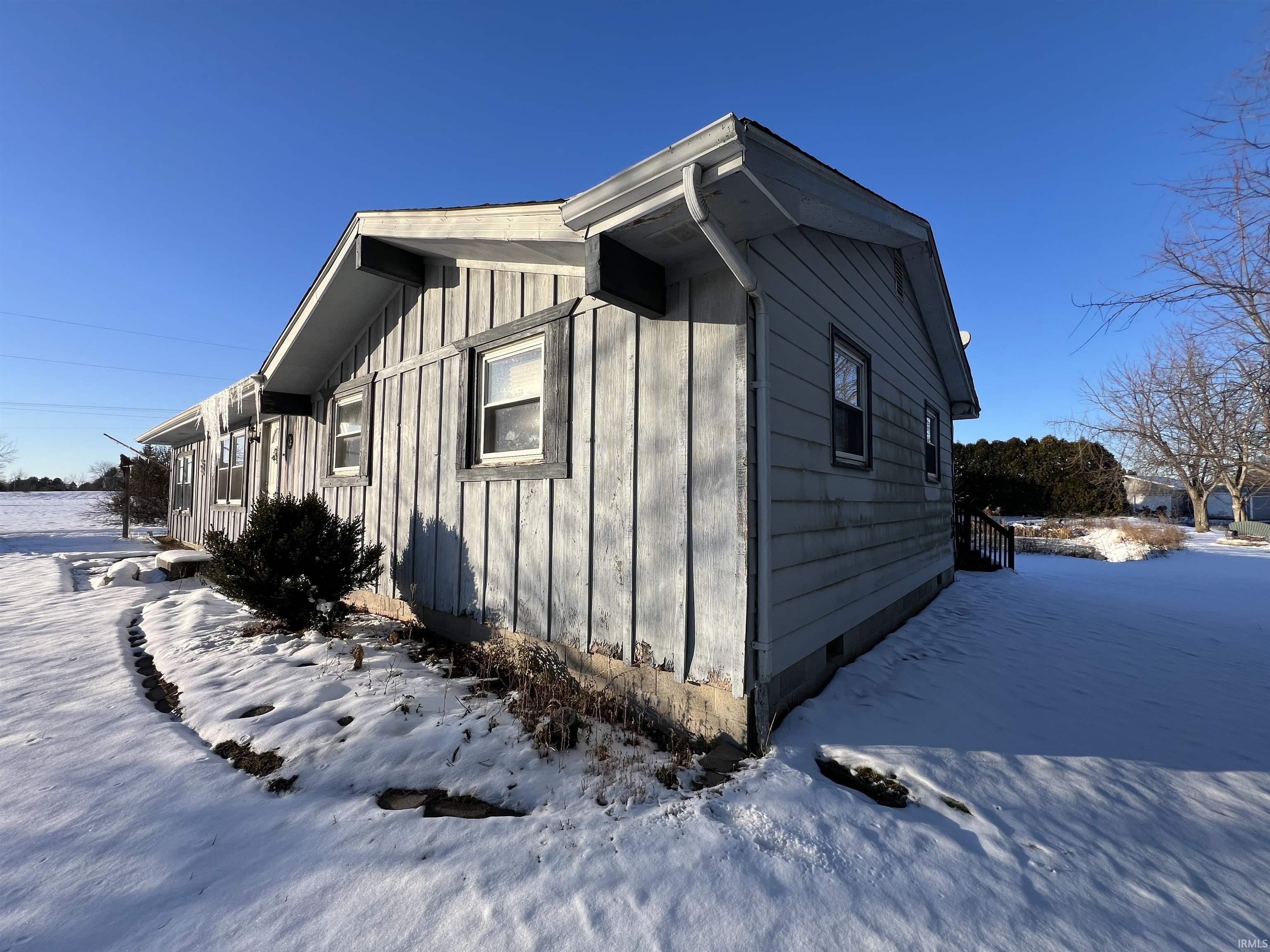 Snow covered property with board and batten siding