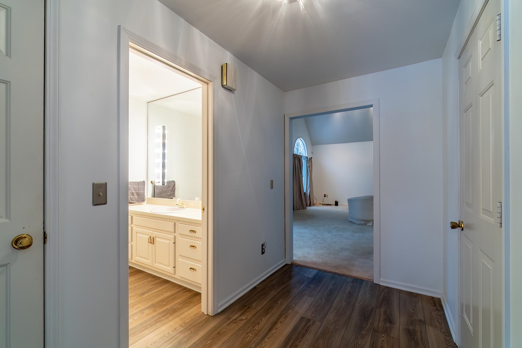 Hallway featuring dark wood-style flooring and baseboards