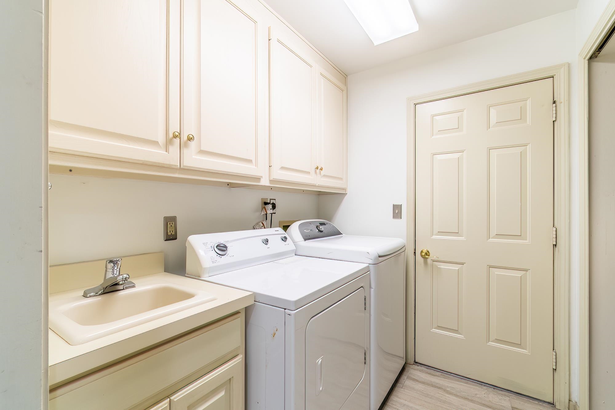 Washroom with cabinet space, separate washer and dryer, and light wood-type flooring