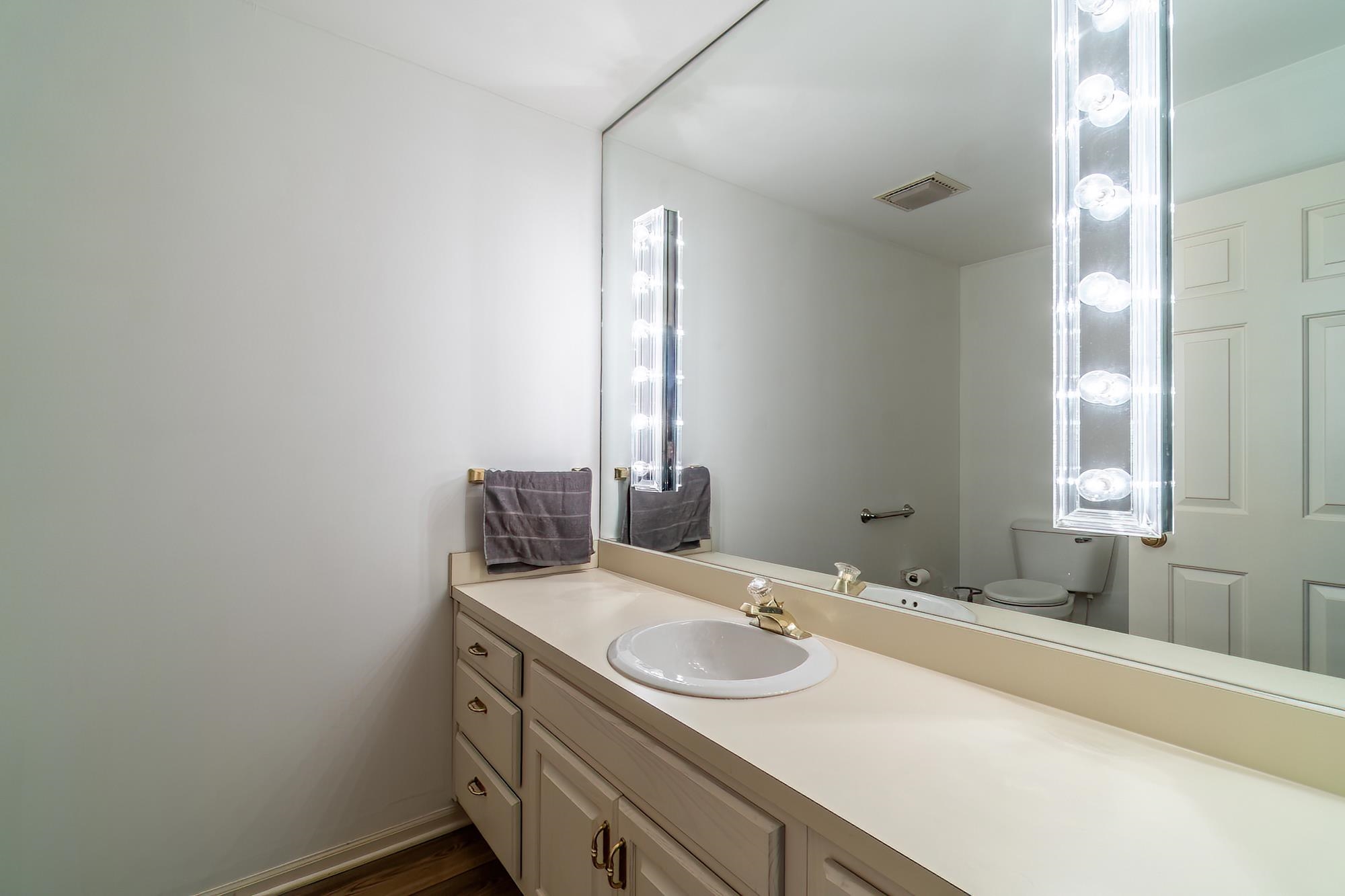 Half bath featuring vanity and dark wood-style floors