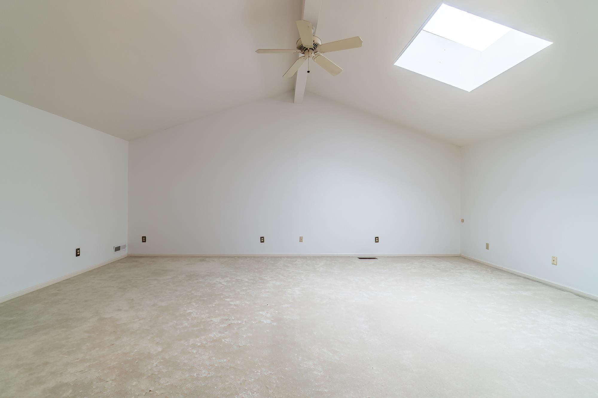 Bonus room featuring a skylight, a ceiling fan, and concrete floors