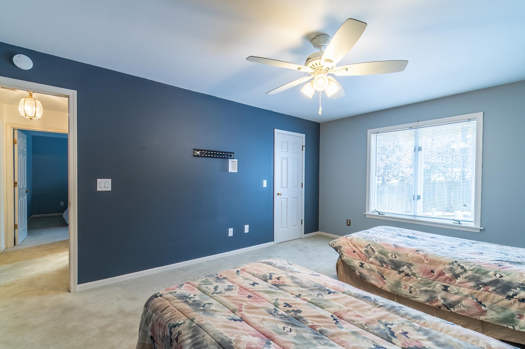 Carpeted bedroom featuring baseboards and ceiling fan