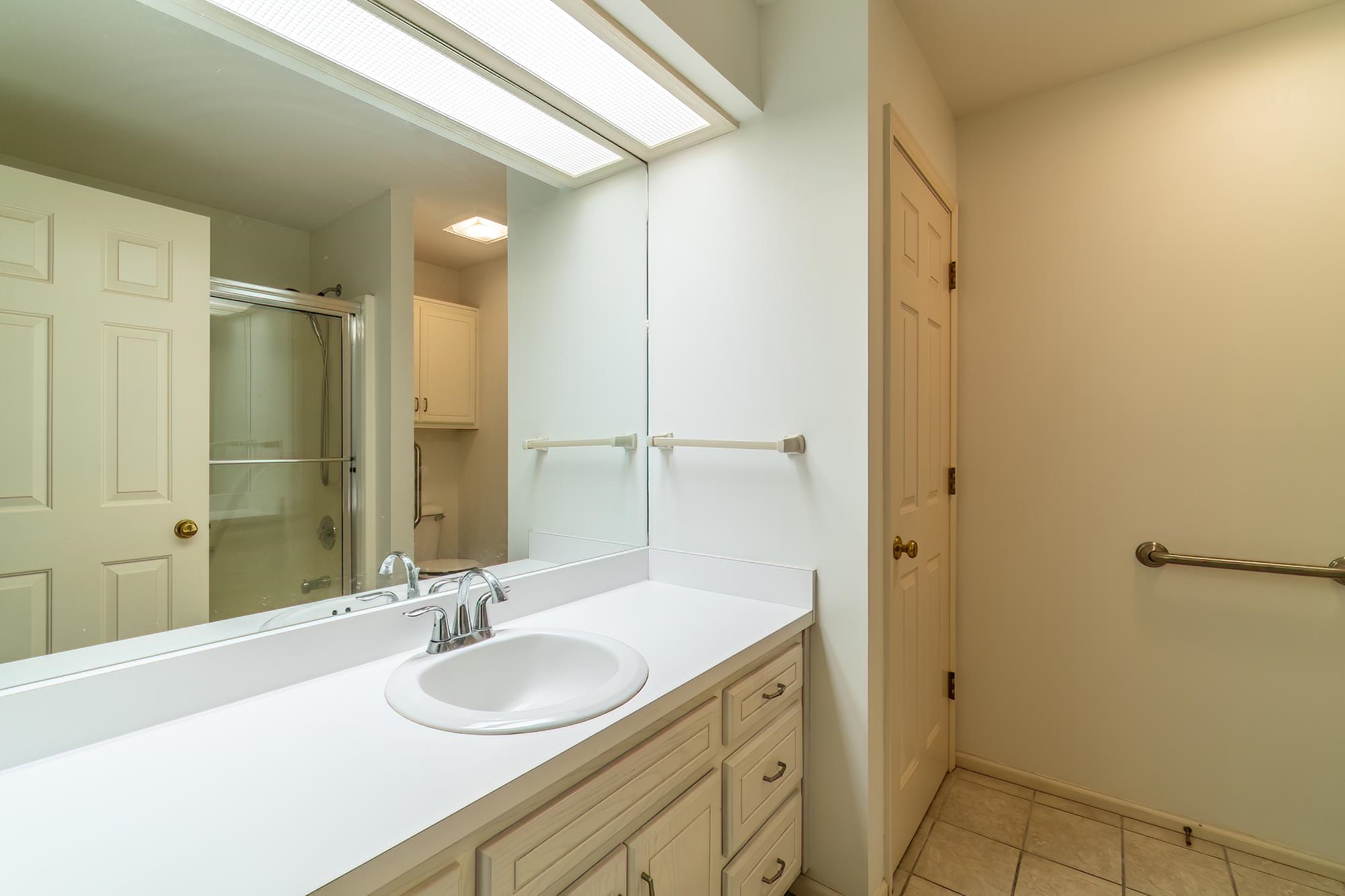 Full bathroom with a shower stall, vanity, and light tile patterned flooring