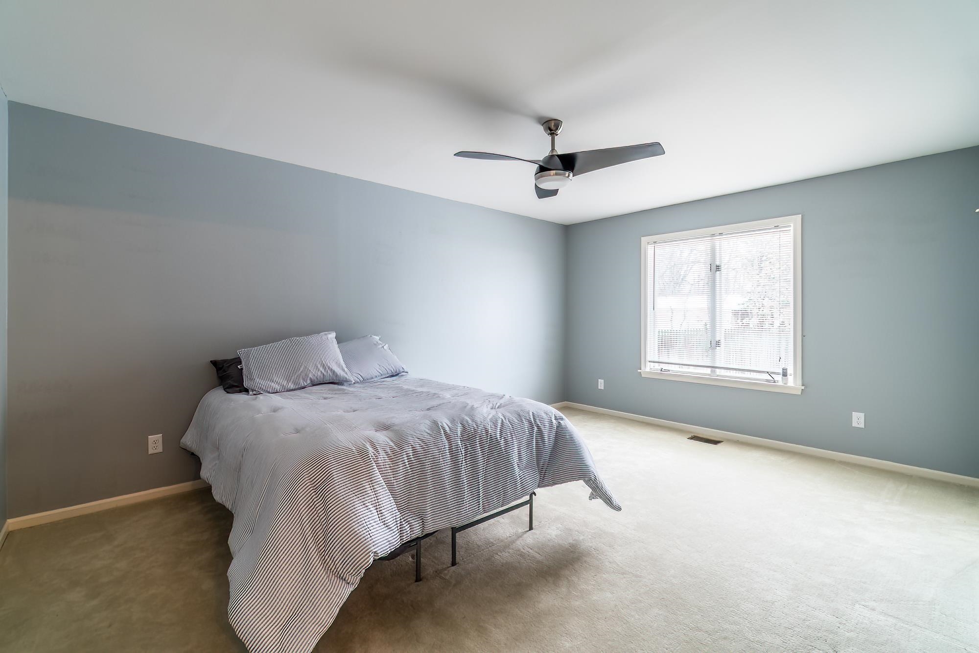 Carpeted bedroom featuring baseboards and a ceiling fan