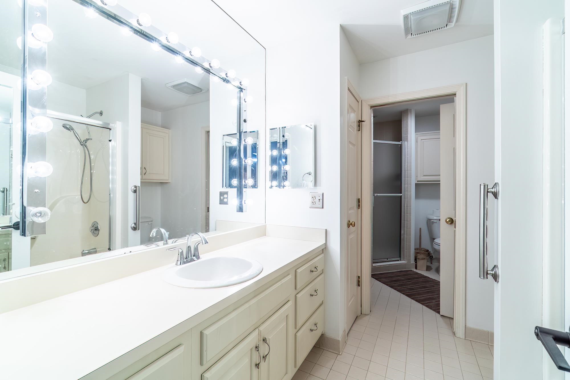 Bathroom featuring a shower stall, vanity, and light tile patterned floors