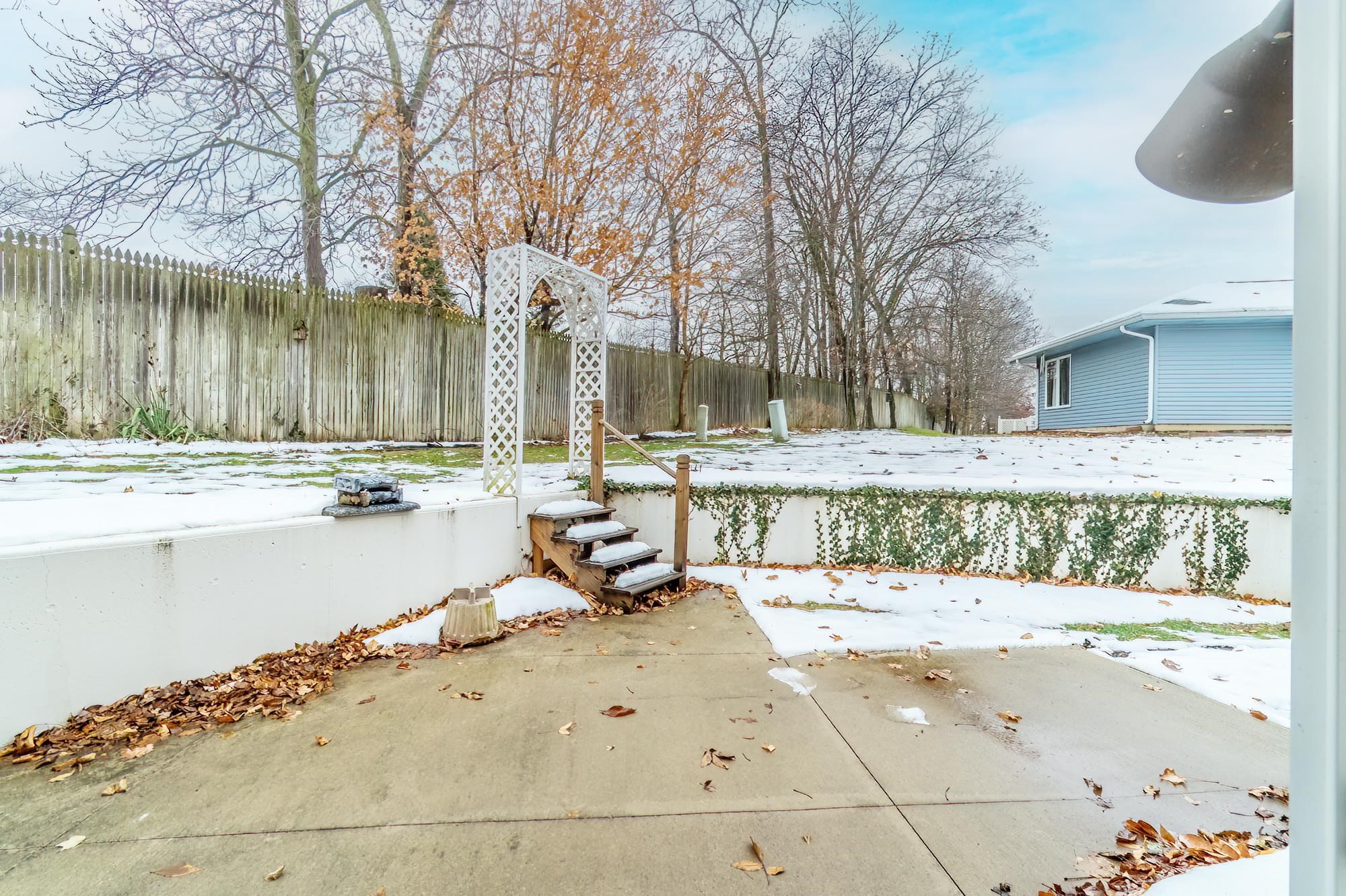 Snow covered patio featuring a fenced backyard and a patio area