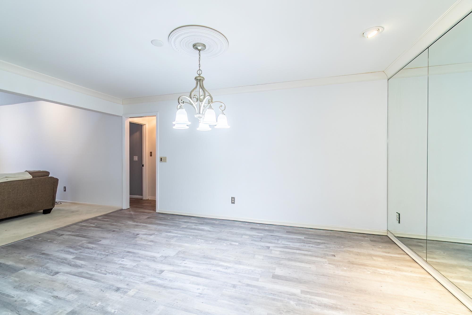Unfurnished dining area with light wood-type flooring, ornamental molding, and a chandelier
