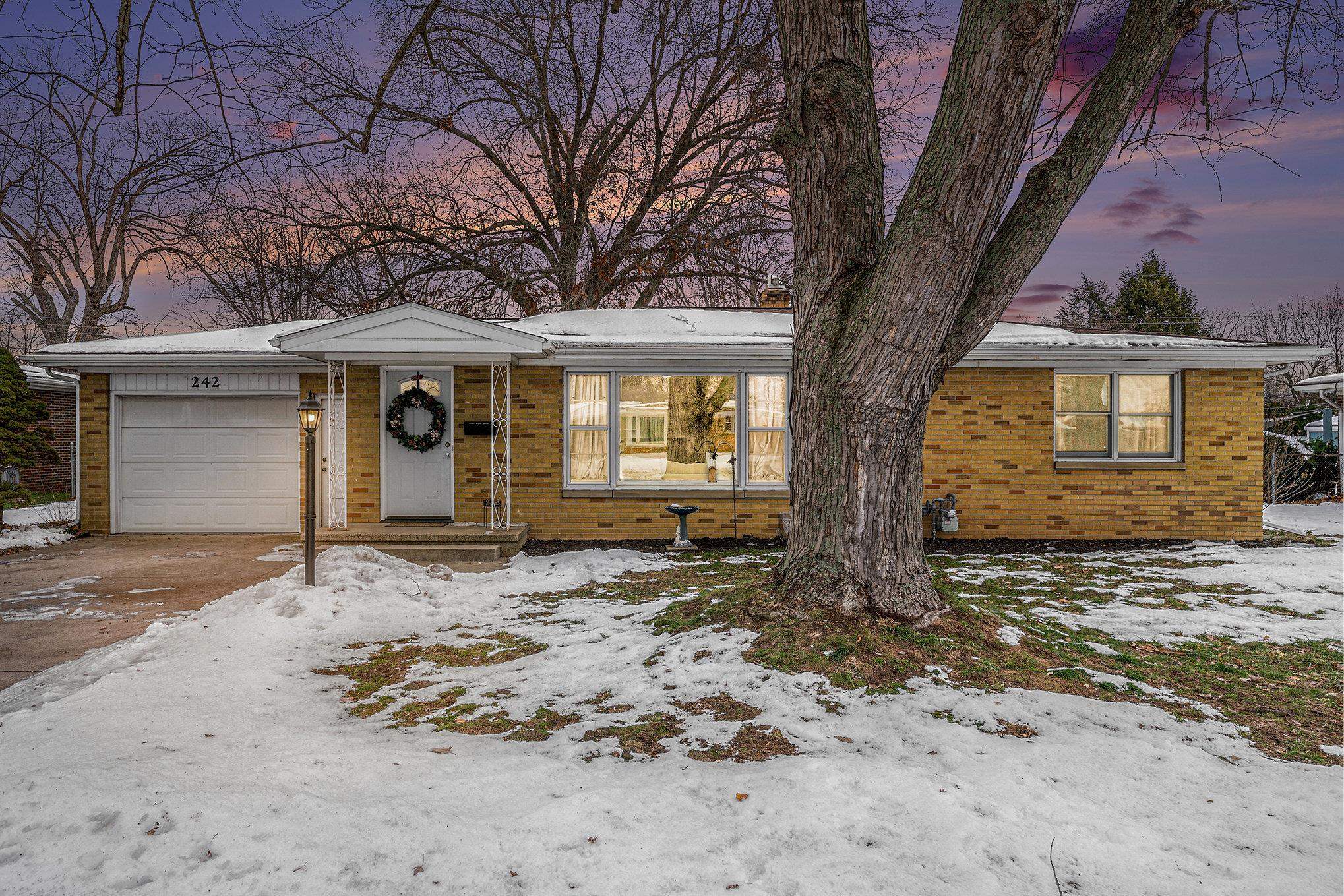 View of front of house with brick siding and an attached garage