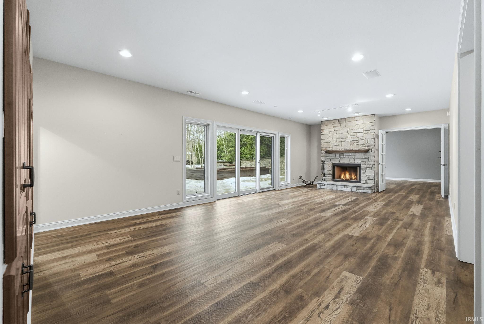 Luxury Plank Floor, Stone Fireplace, Built-in Shelves with lighting, and 900+ unfinished sq. ft for storage and hobbies.