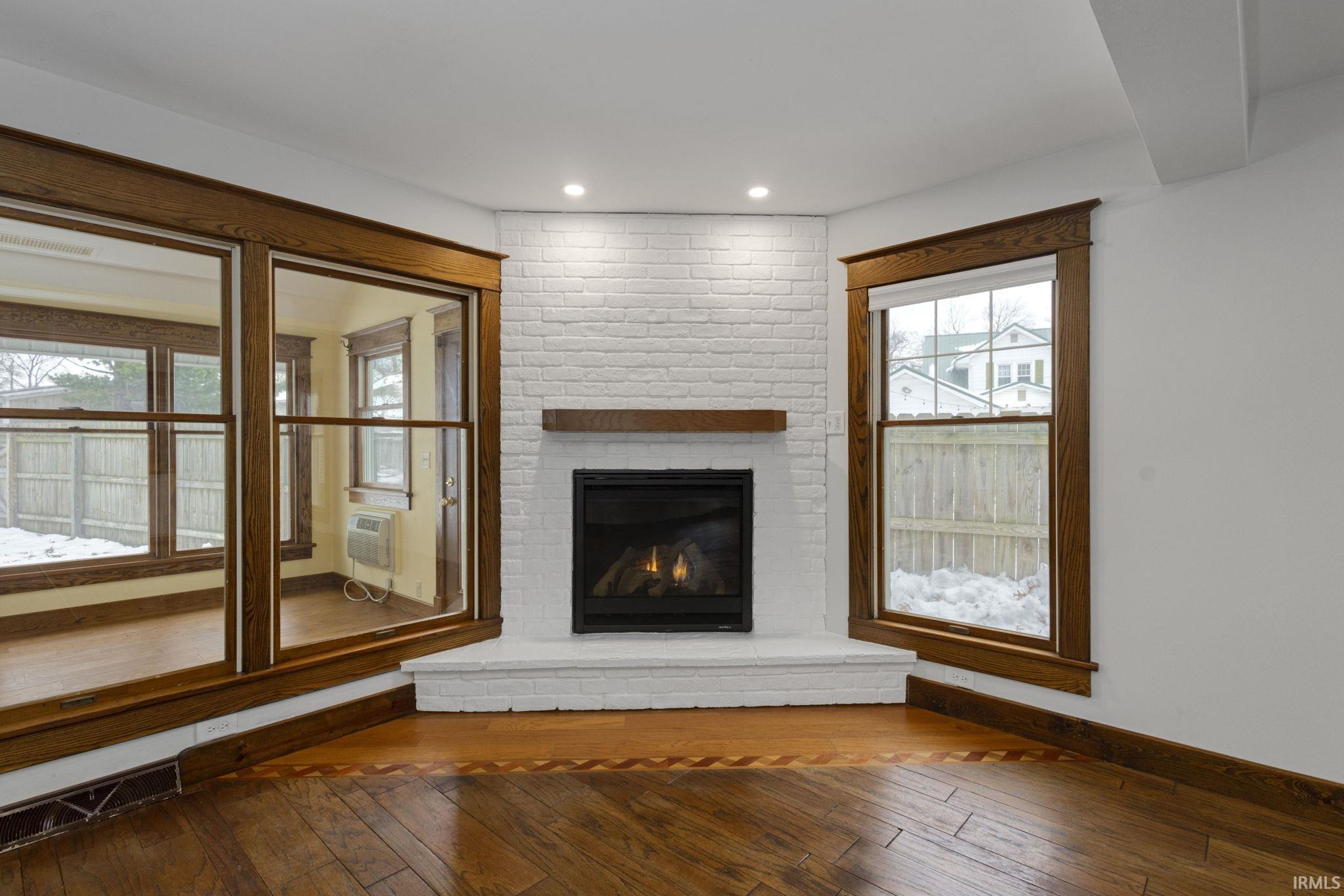 Unfurnished living room featuring hardwood / wood-style flooring, a fireplace, and plenty of natural light