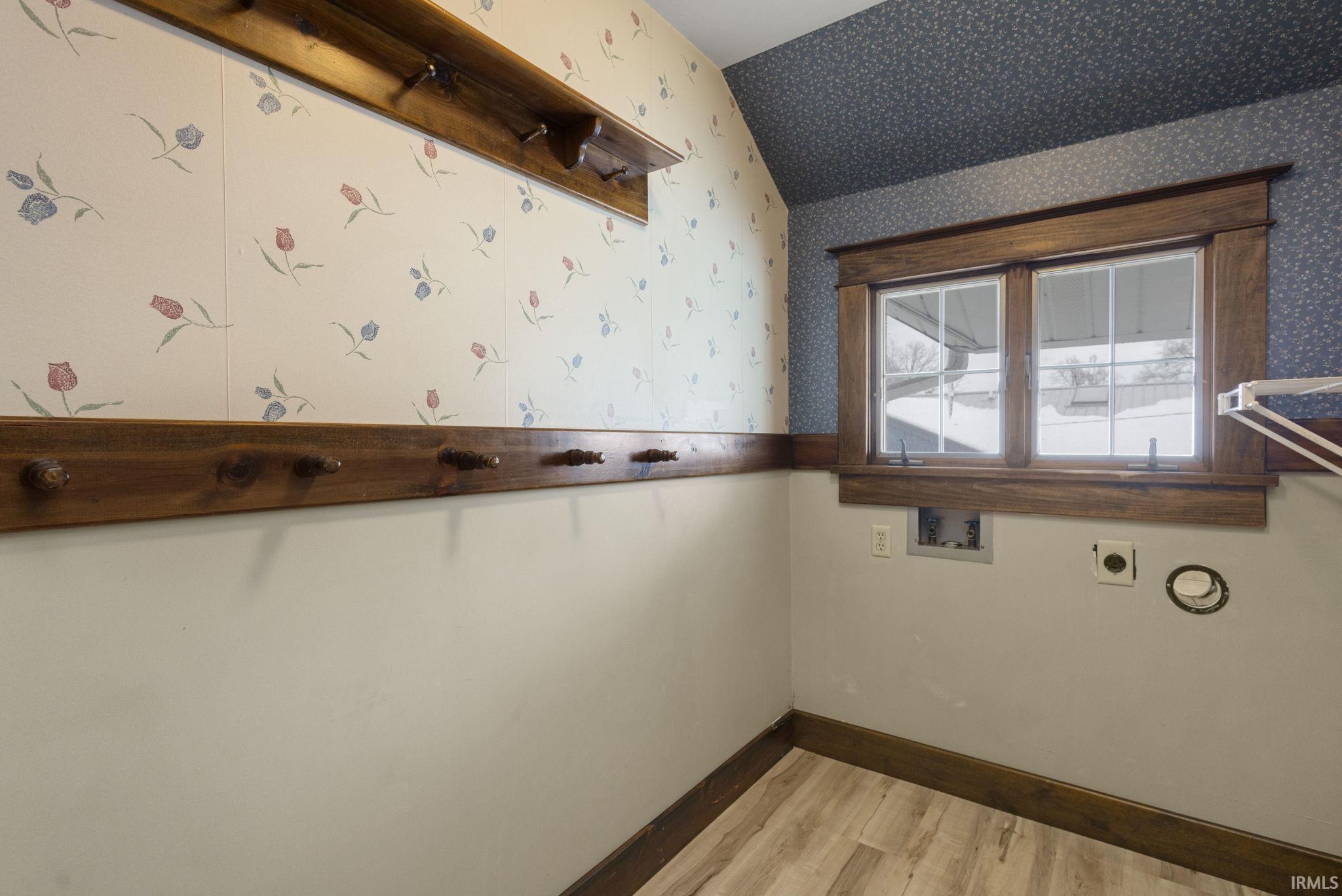 Spare room with wallpapered walls and light wood finished floors