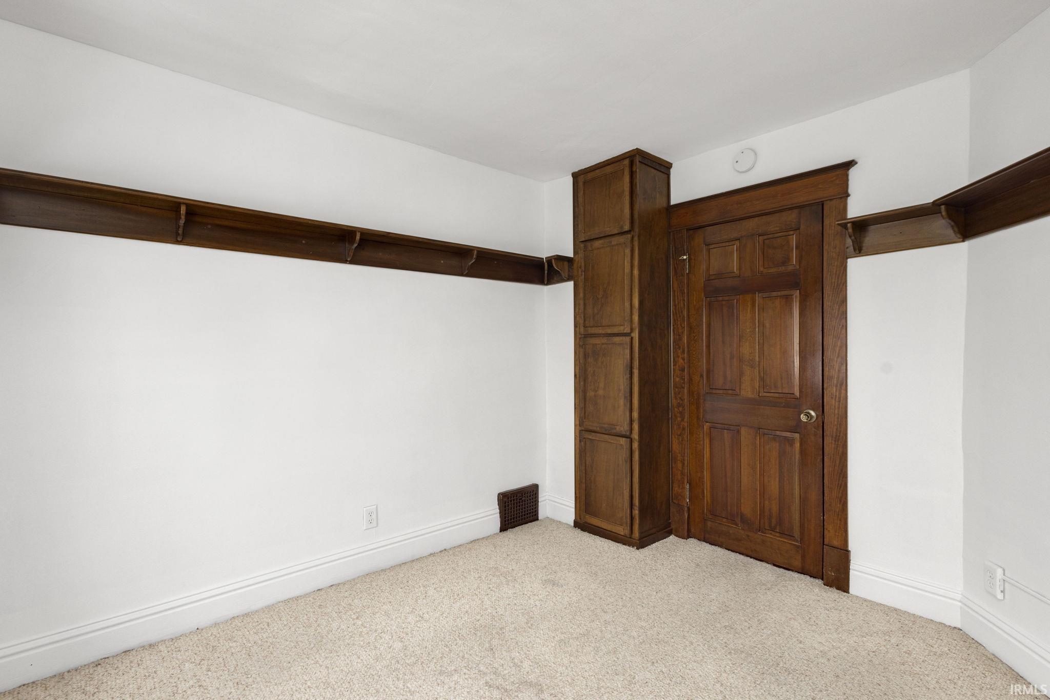Unfurnished bedroom featuring light colored carpet and baseboards