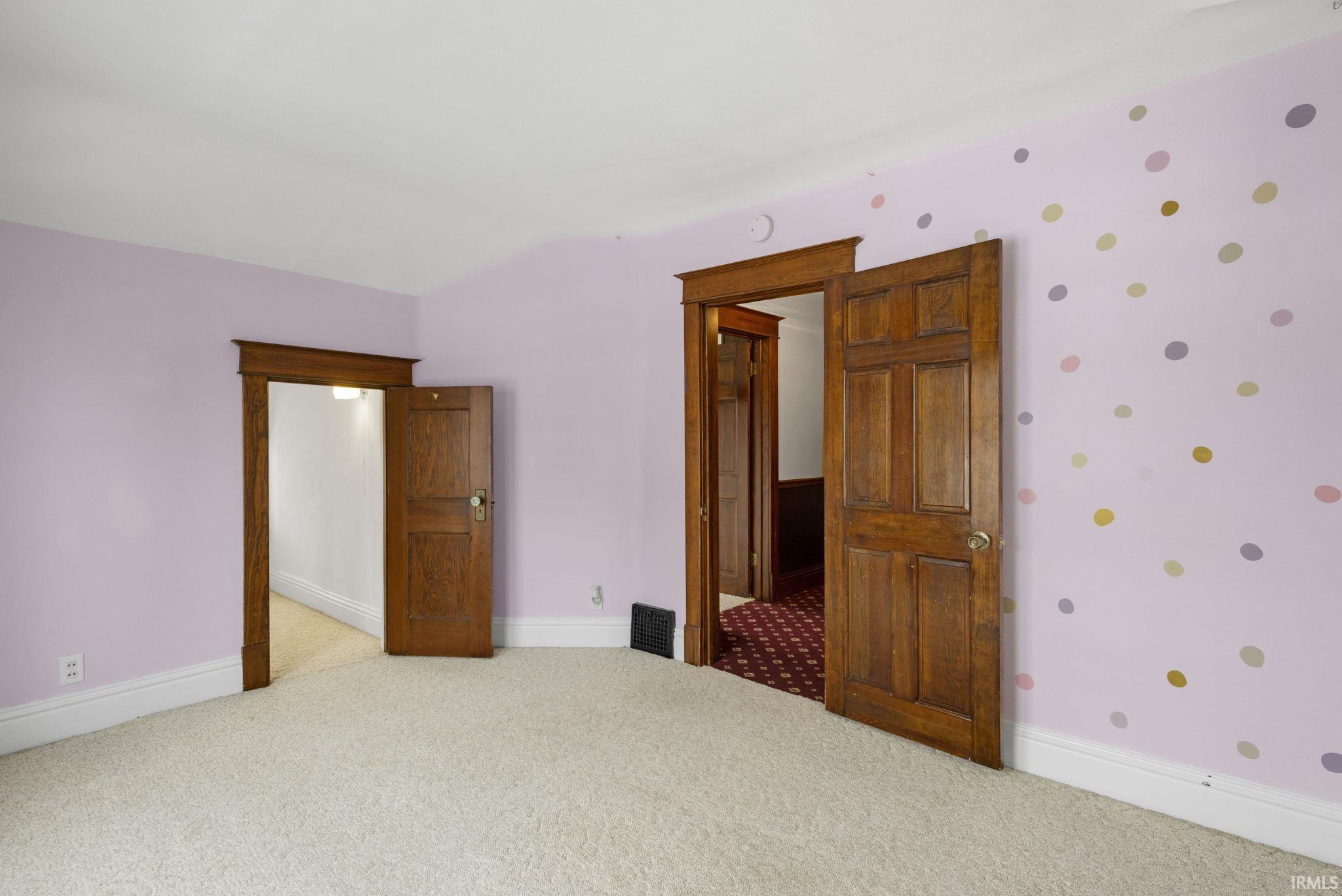Carpeted spare room featuring baseboards