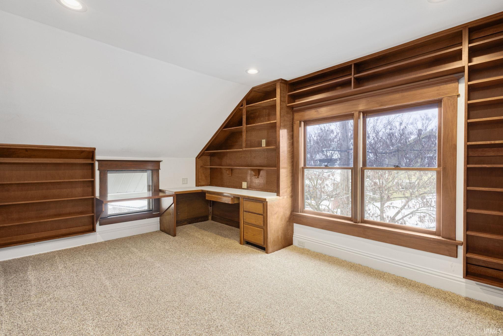Unfurnished office with lofted ceiling, light carpet, recessed lighting, plenty of natural light, and built in study area