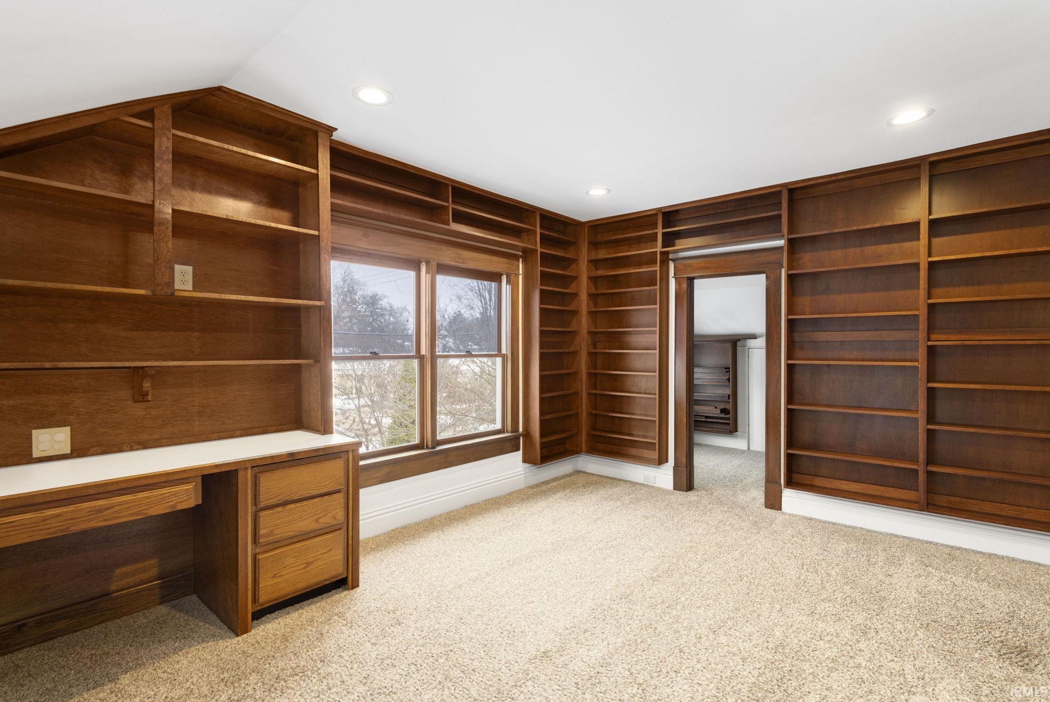 Unfurnished office featuring built in features, light colored carpet, and recessed lighting