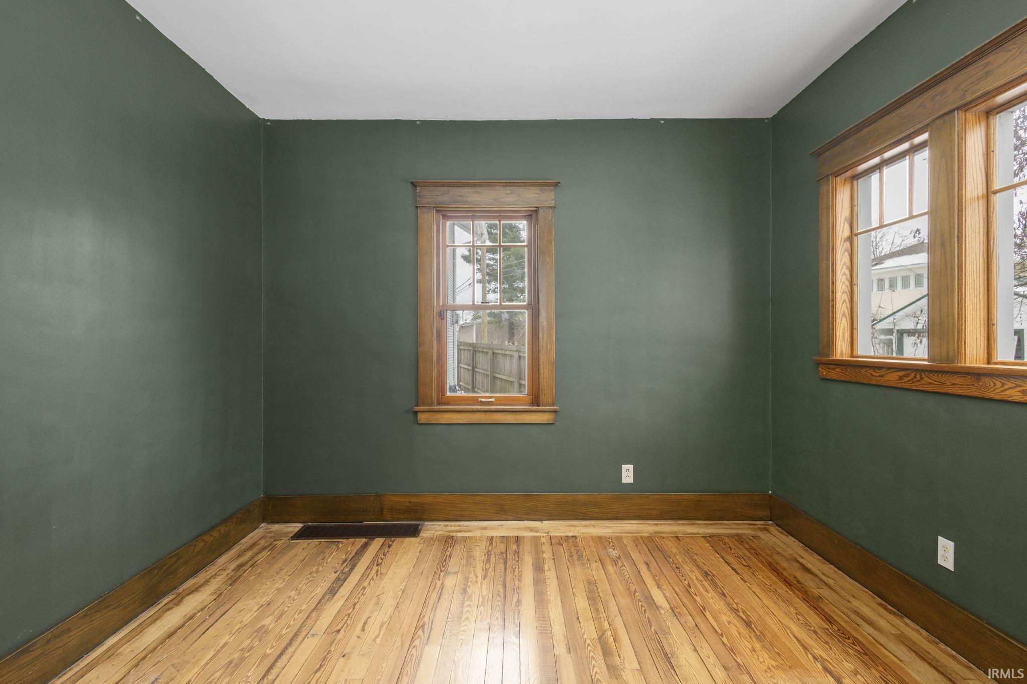 Empty room featuring hardwood / wood-style flooring and baseboards