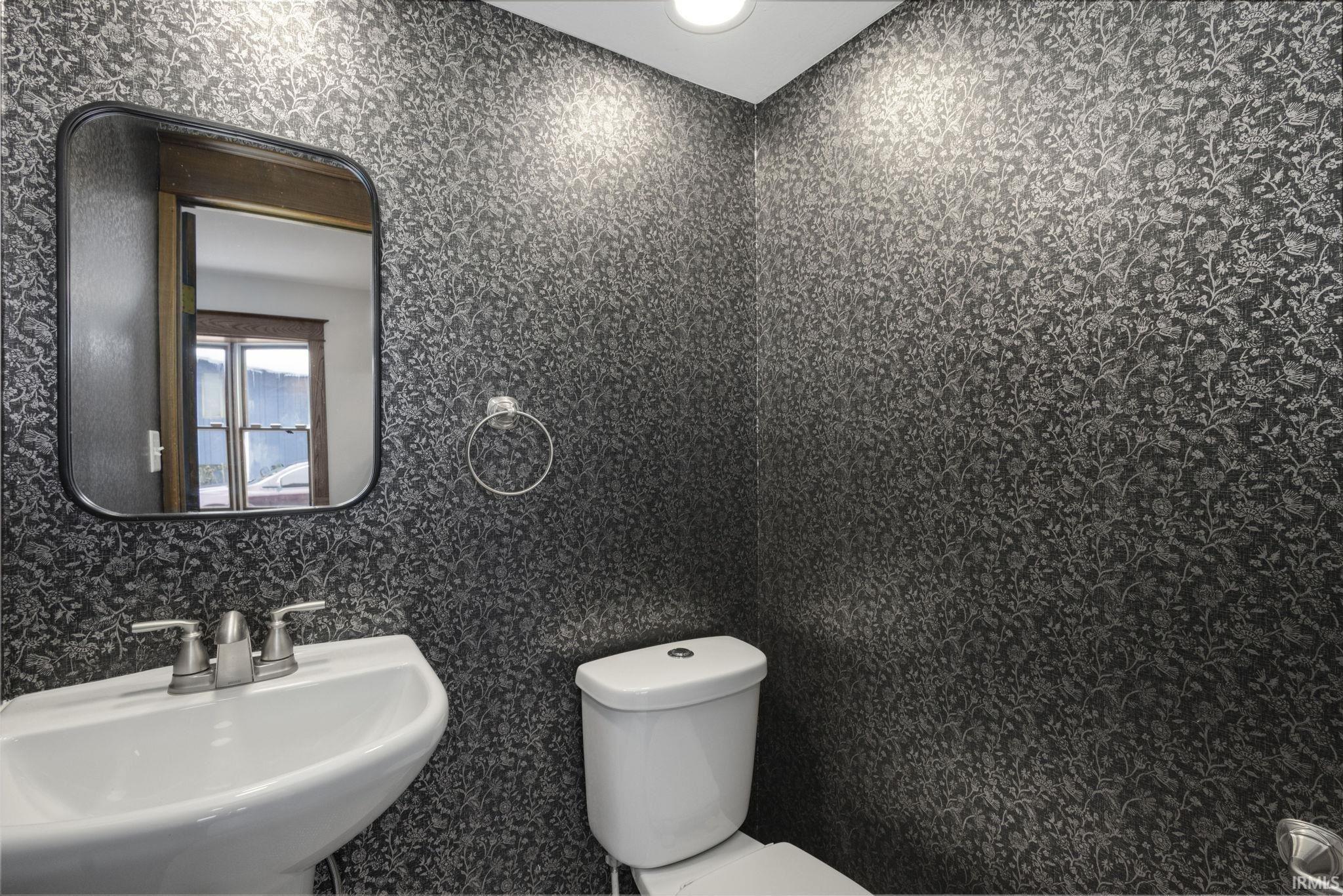 Half bath featuring toilet and a sink