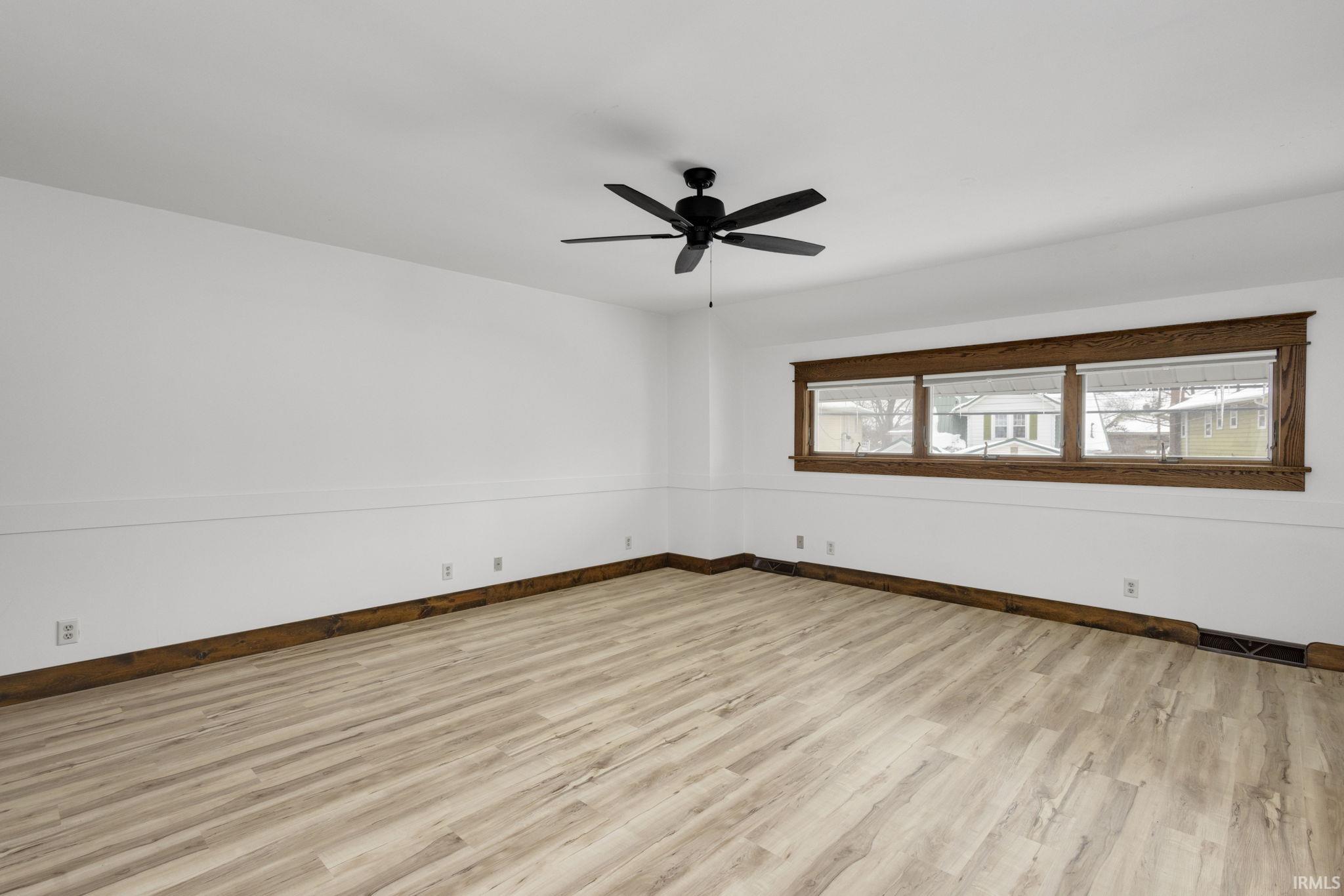 Unfurnished room featuring light wood-style flooring and ceiling fan
