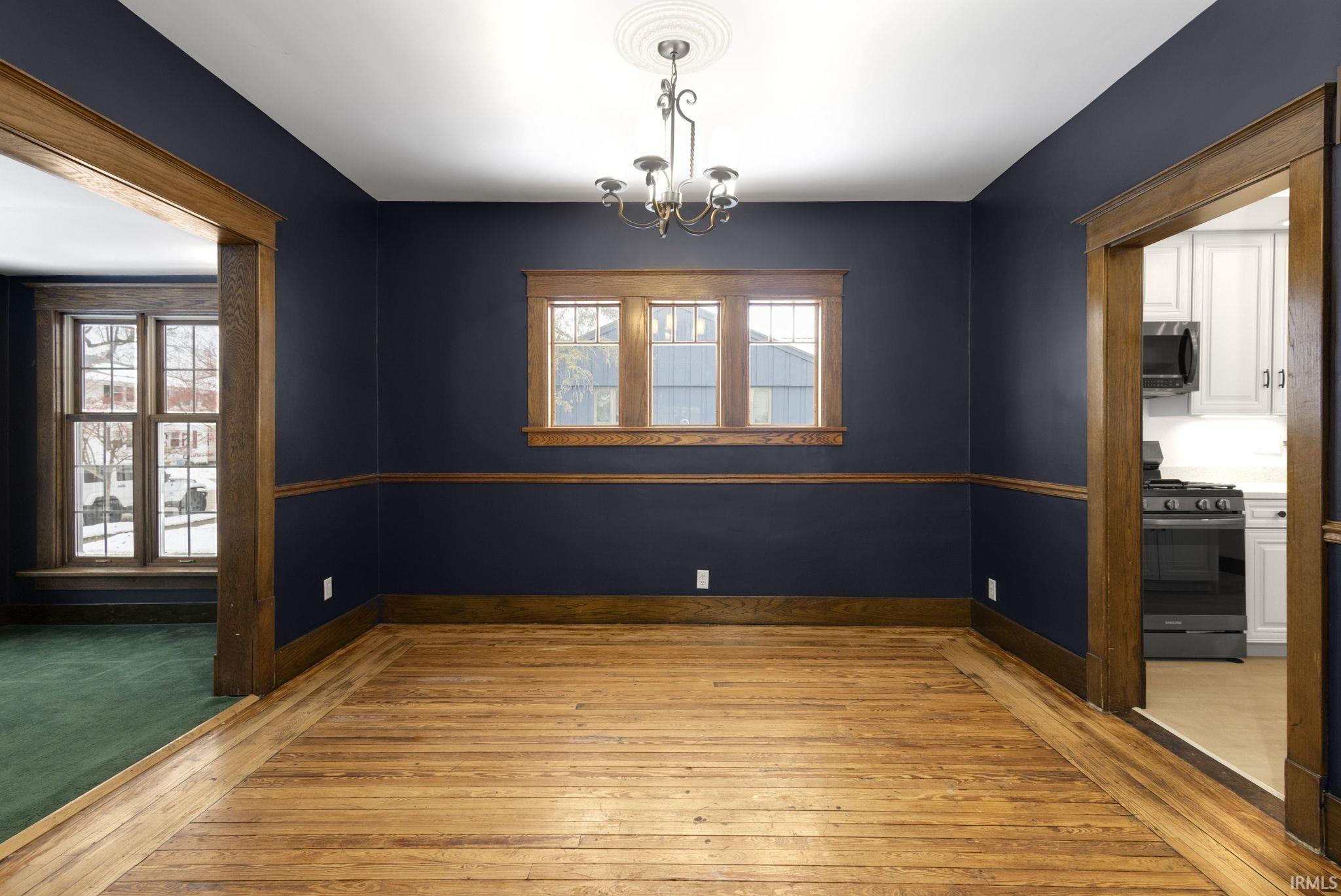 Spare room with light wood-style floors and a chandelier