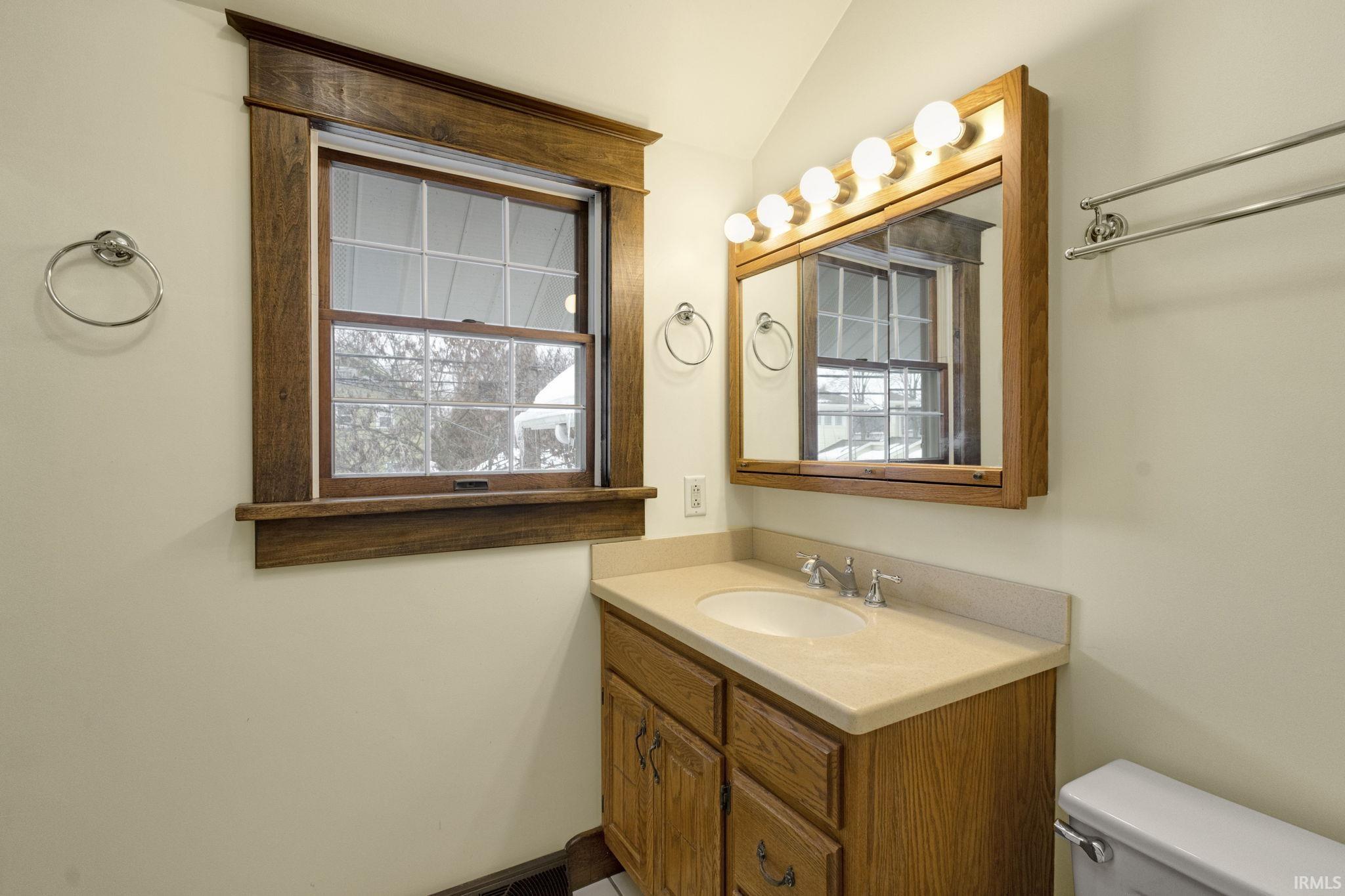 Bathroom featuring vanity and vaulted ceiling