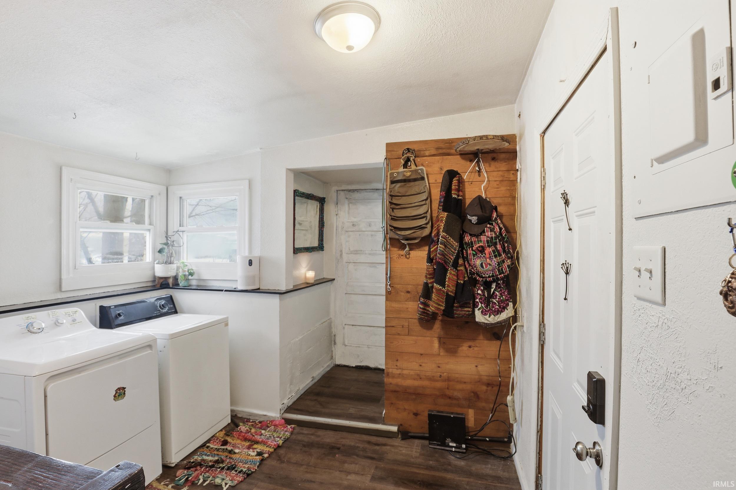 Laundry area featuring dark wood-type flooring and washer and clothes dryer