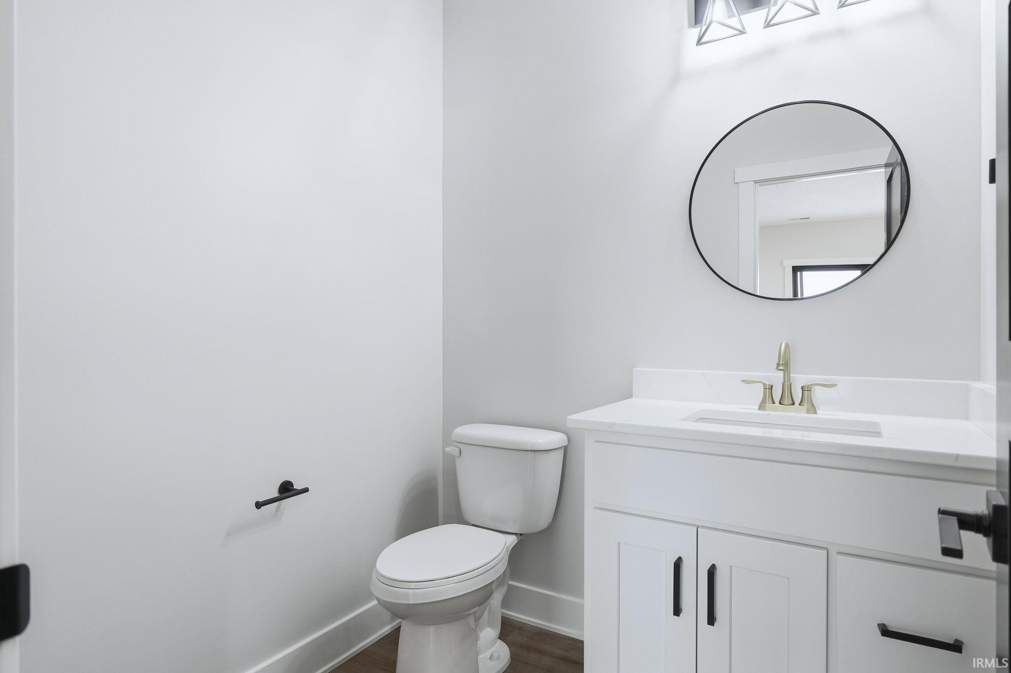Half bath featuring vanity and dark wood-style flooring