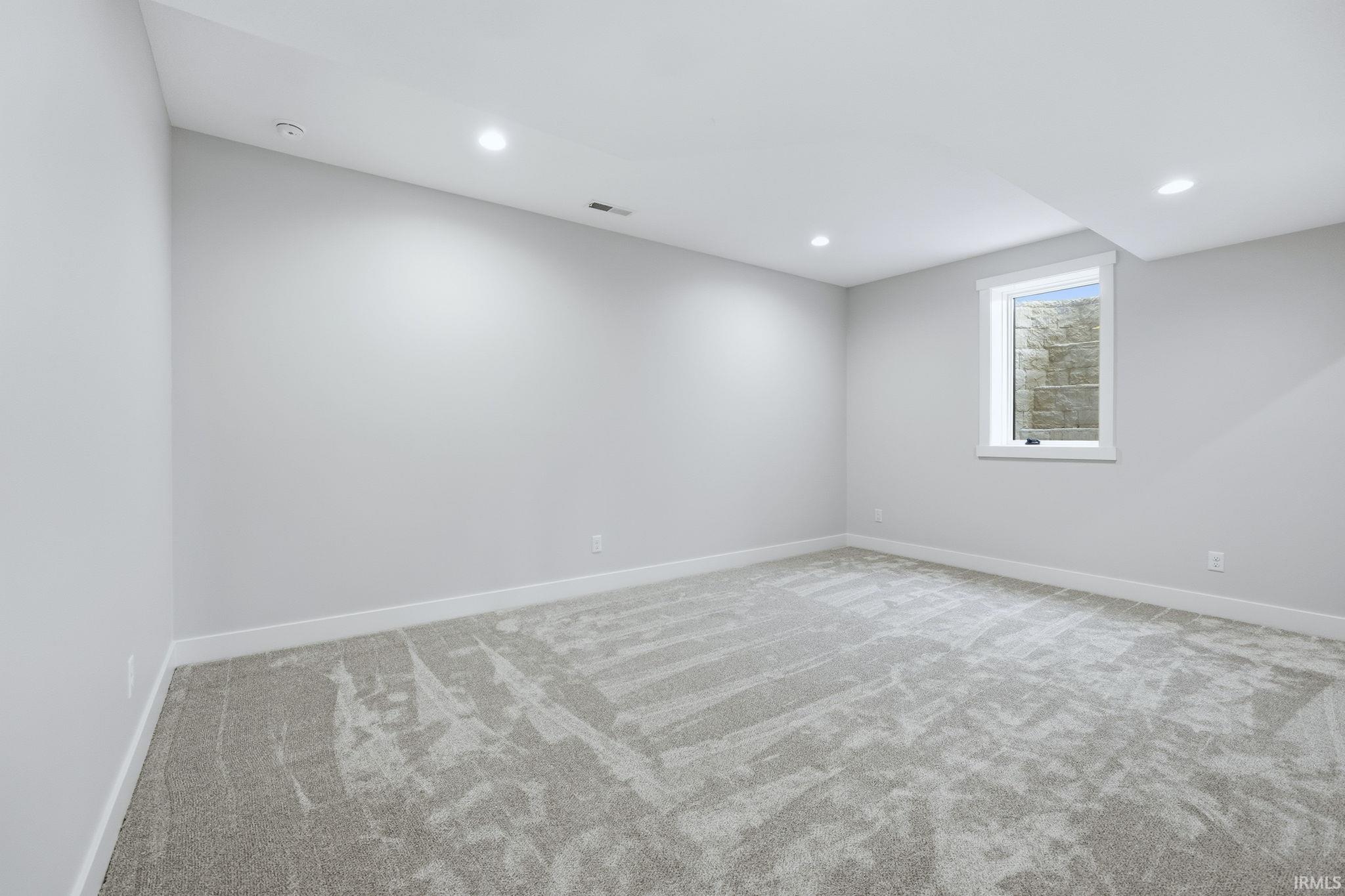 Unfurnished room with light colored carpet and recessed lighting