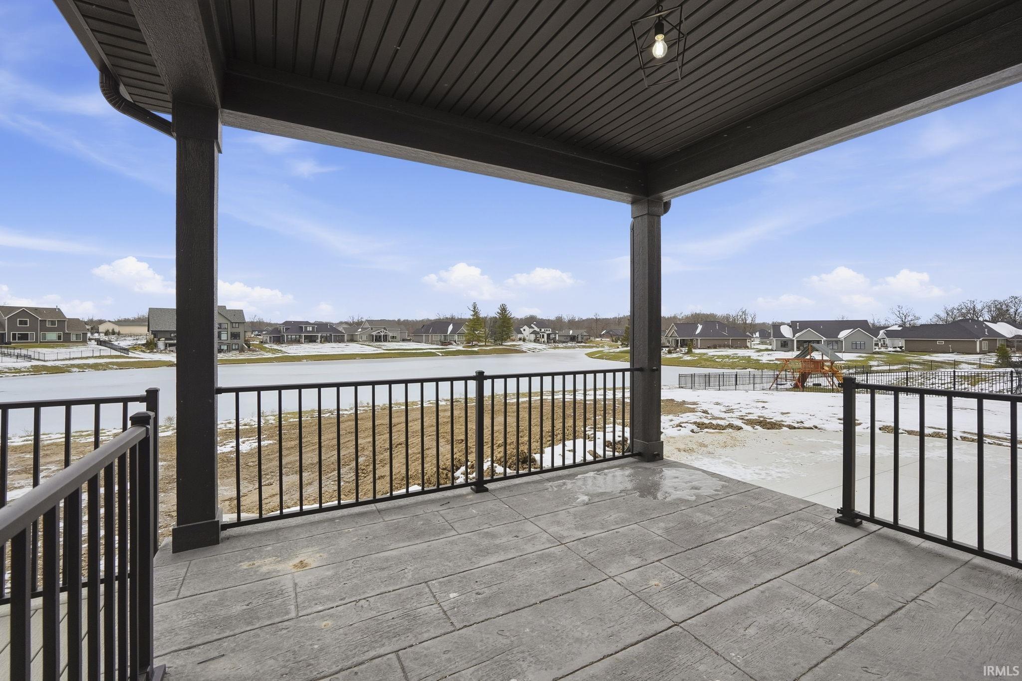Covered porch featuring a residential view and a water view