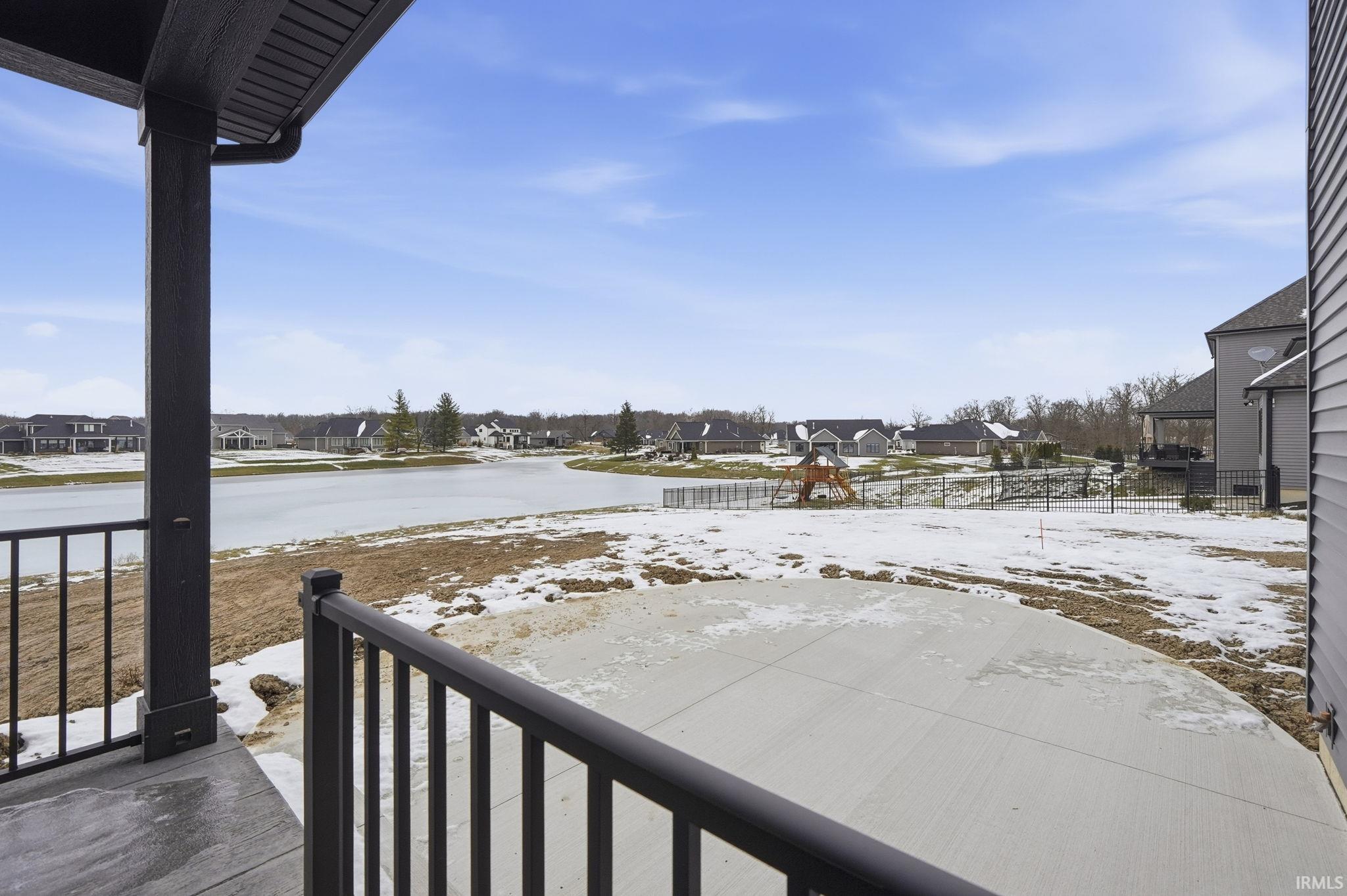 Yard covered in snow featuring covered porch and a residential view